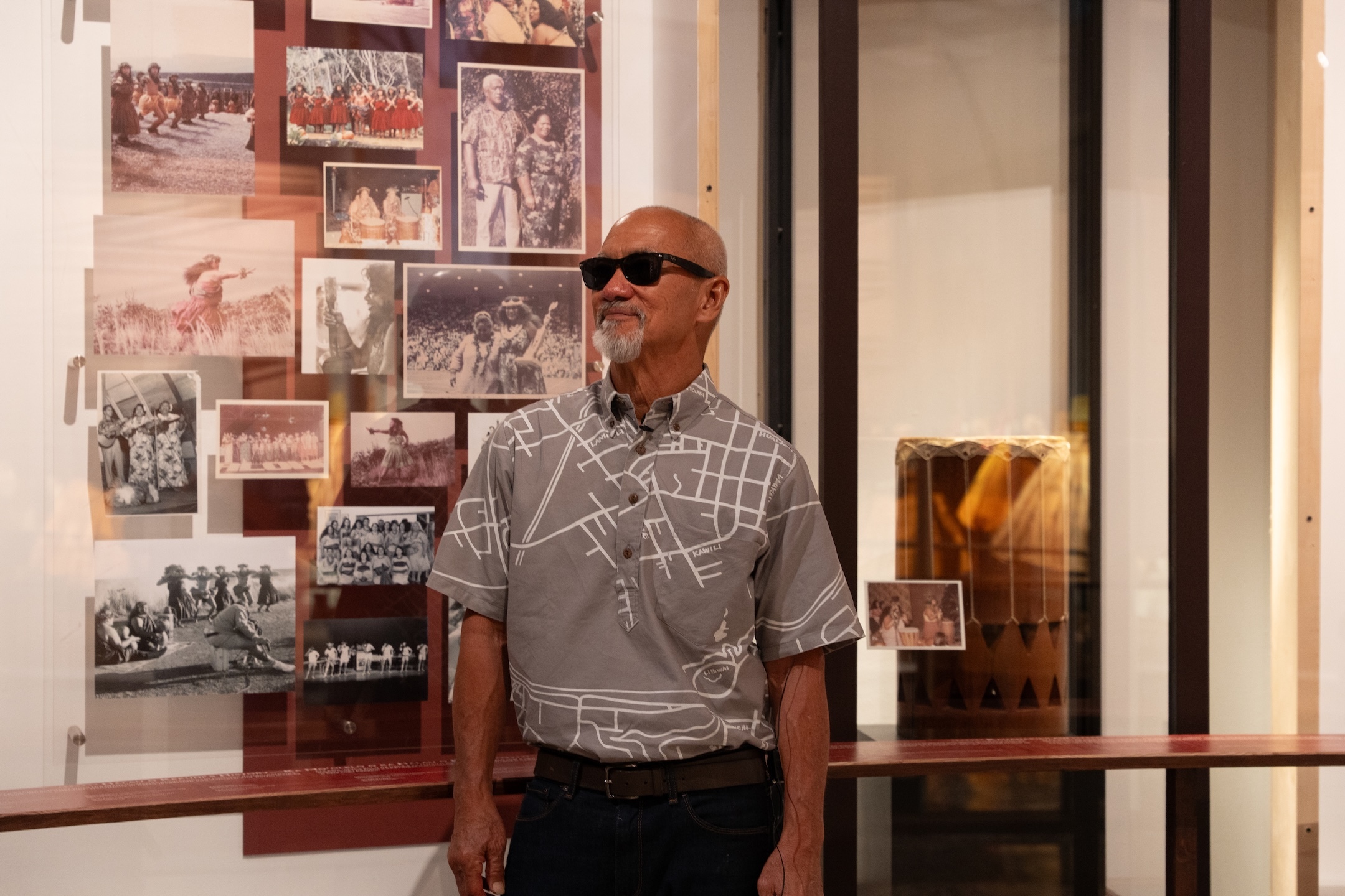 Sig Zane stands by photos, which are part of the special exhibit "Ea Mai ʻEiwa: Patterns of Practice."