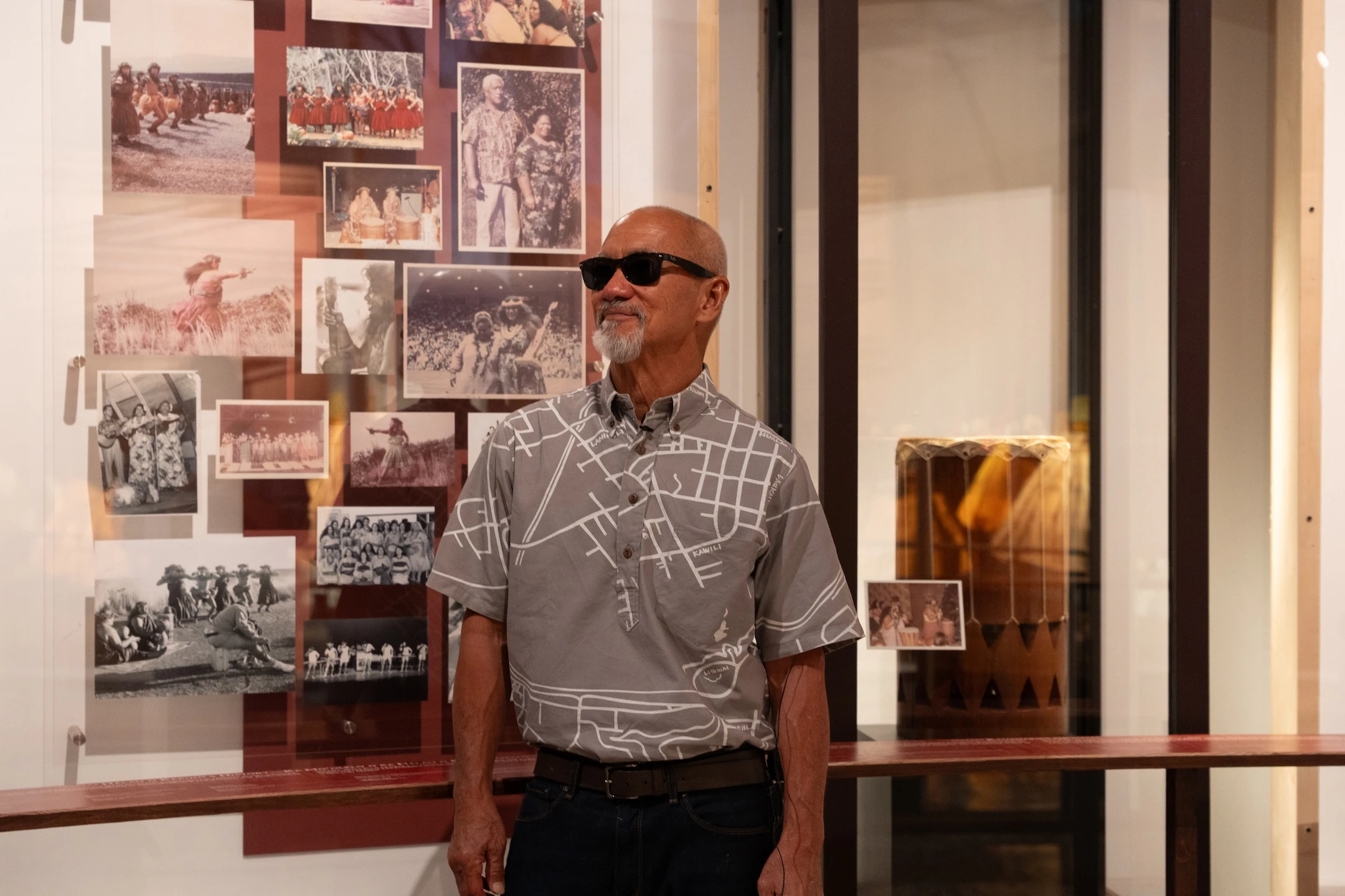 Sig Zane stands by photos, which are part of the special exhibit "Ea Mai ʻEiwa: Patterns of Practice."