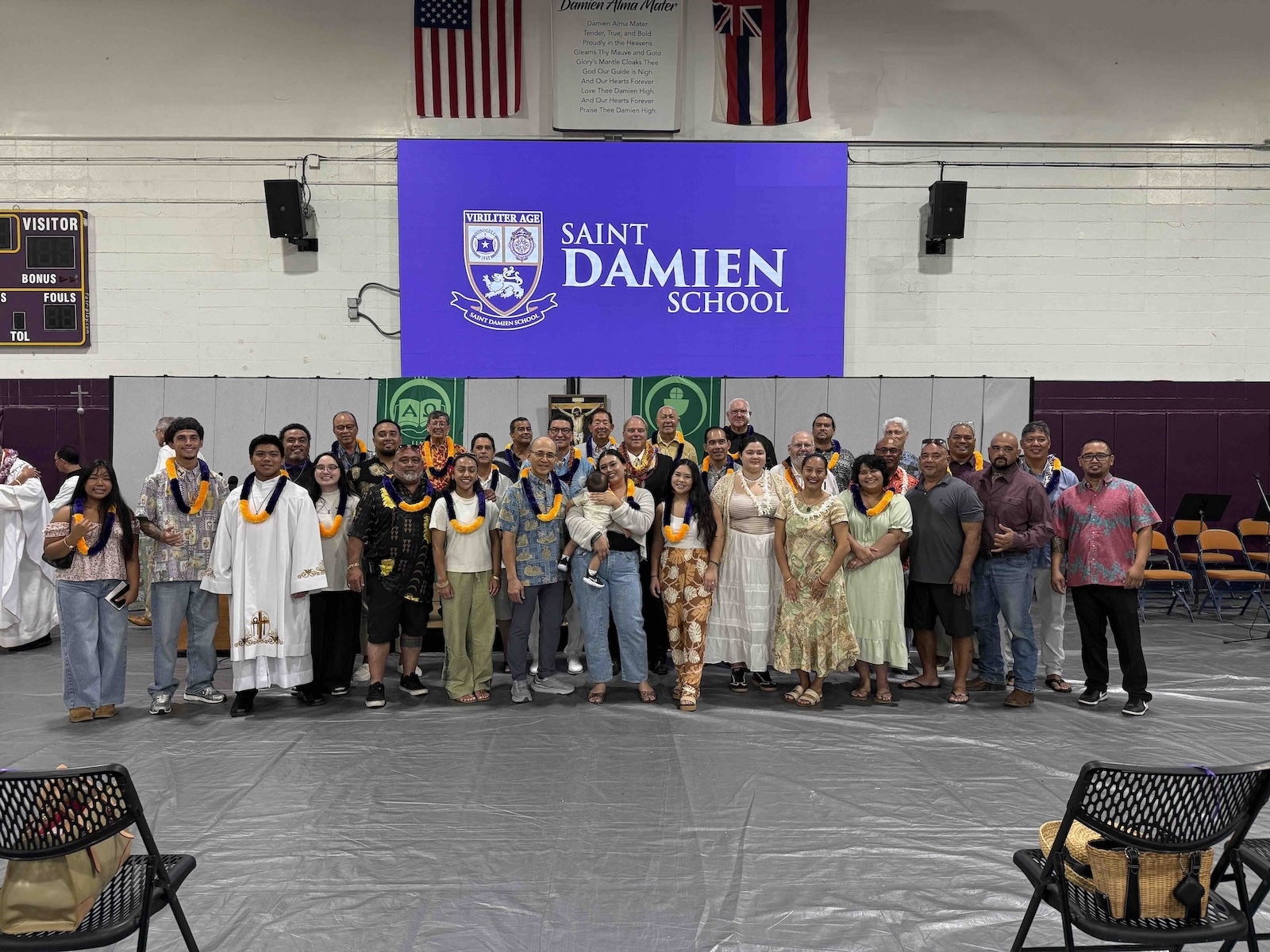 Saint Damien School alumni pose with Board Chair Lanson Kupau (center left) and President and CEO Wally Marciel (center right).