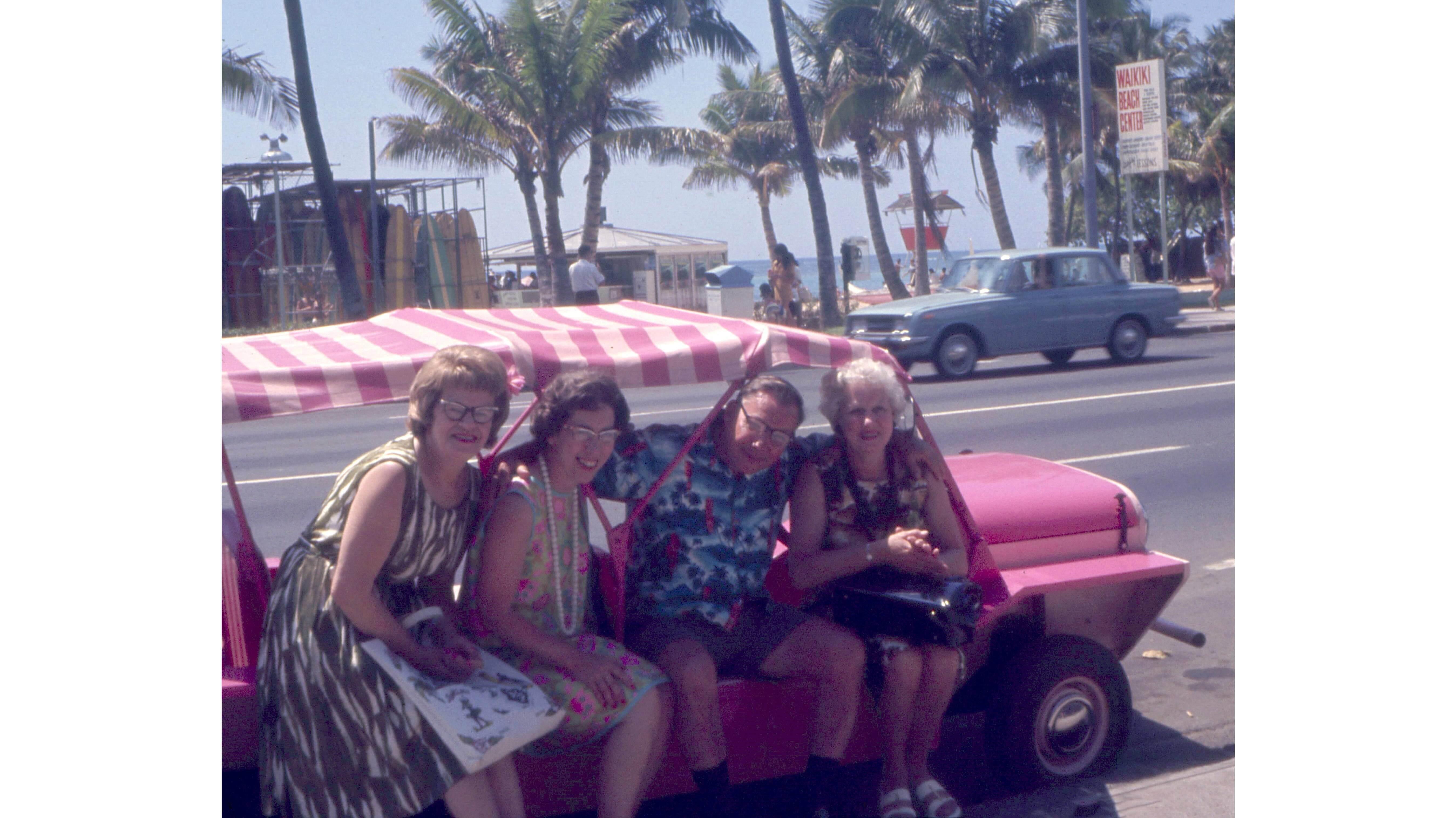Tourists in a pink Mini Moke 1960s