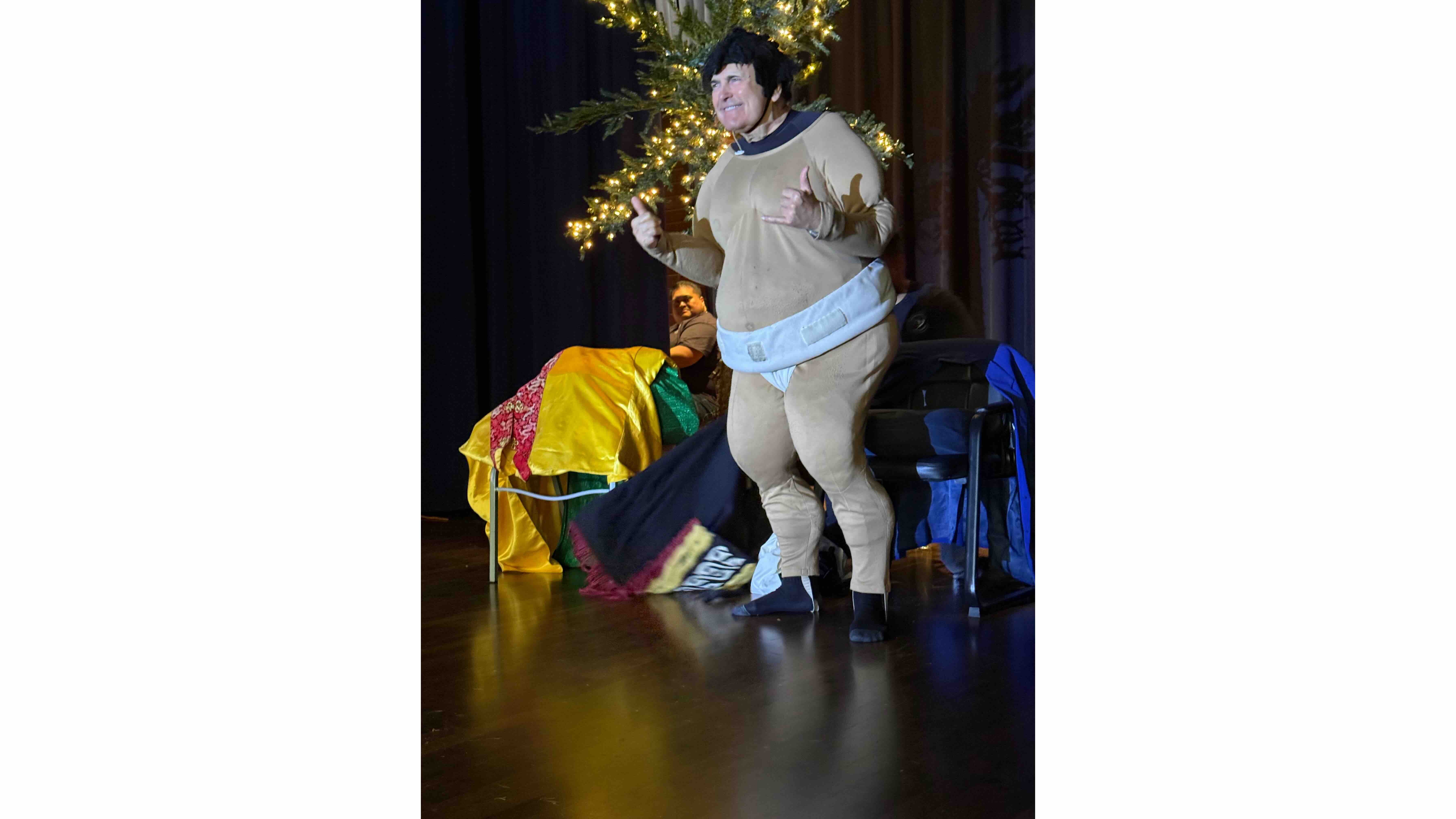 De Lima sporting a sumo wrestler fat suit, flashing shakas.