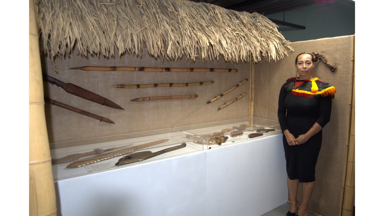 Michelle Manu and the museum's display of traditional Hawaiian weapons.