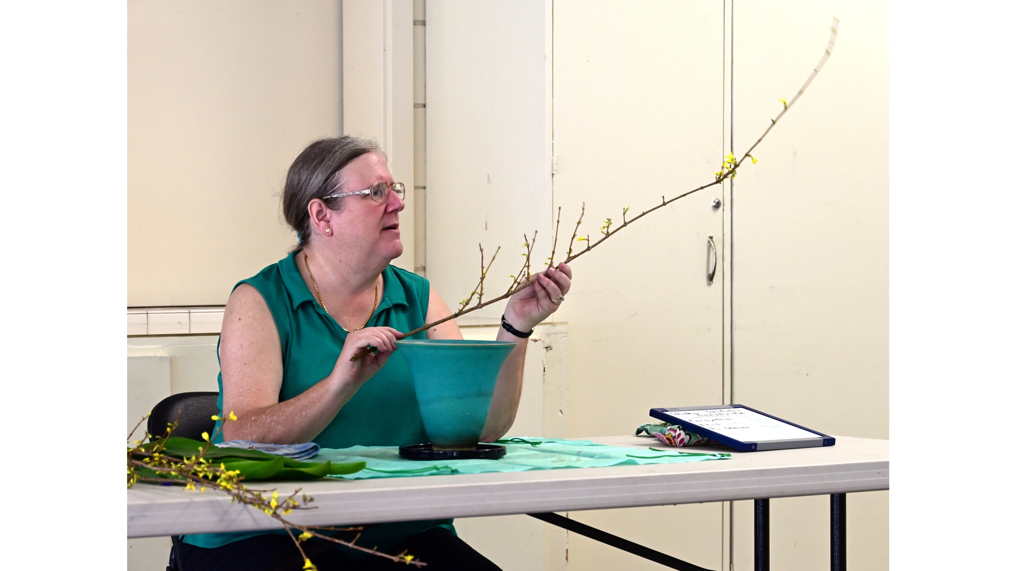 Tinius examines a forsythia branch for possible use in an arrangement.