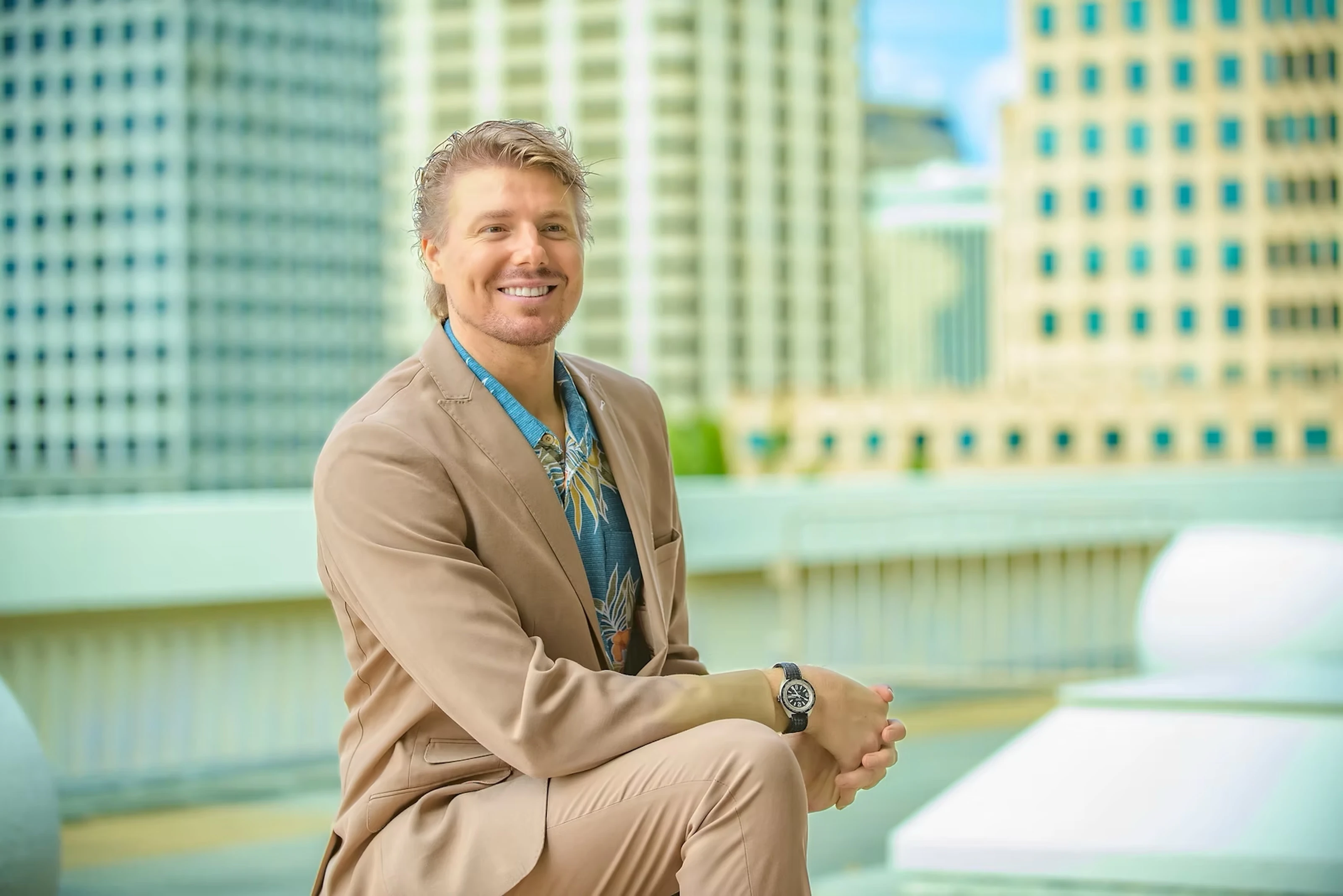 A photo of a man in a beige suit atop the Hawaii State Capitol Building.