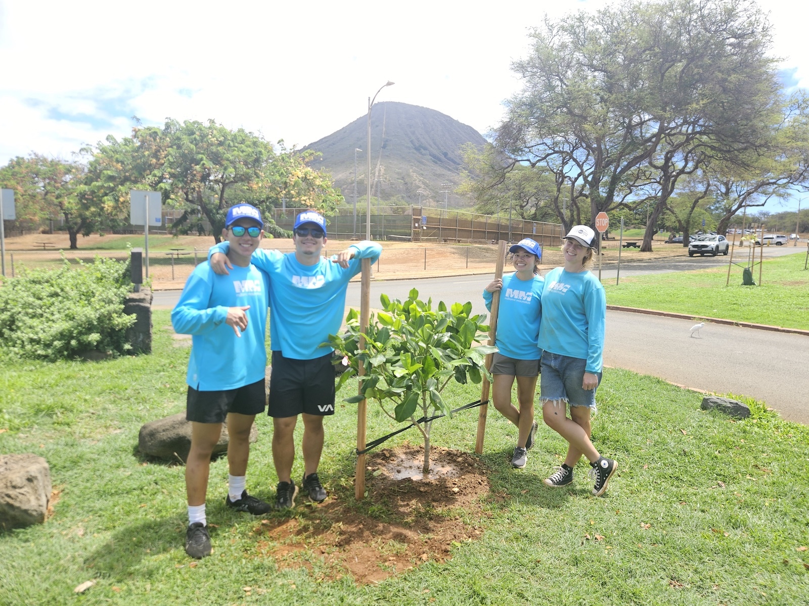 Mālama Maunalua volunteers pose with a native plant.