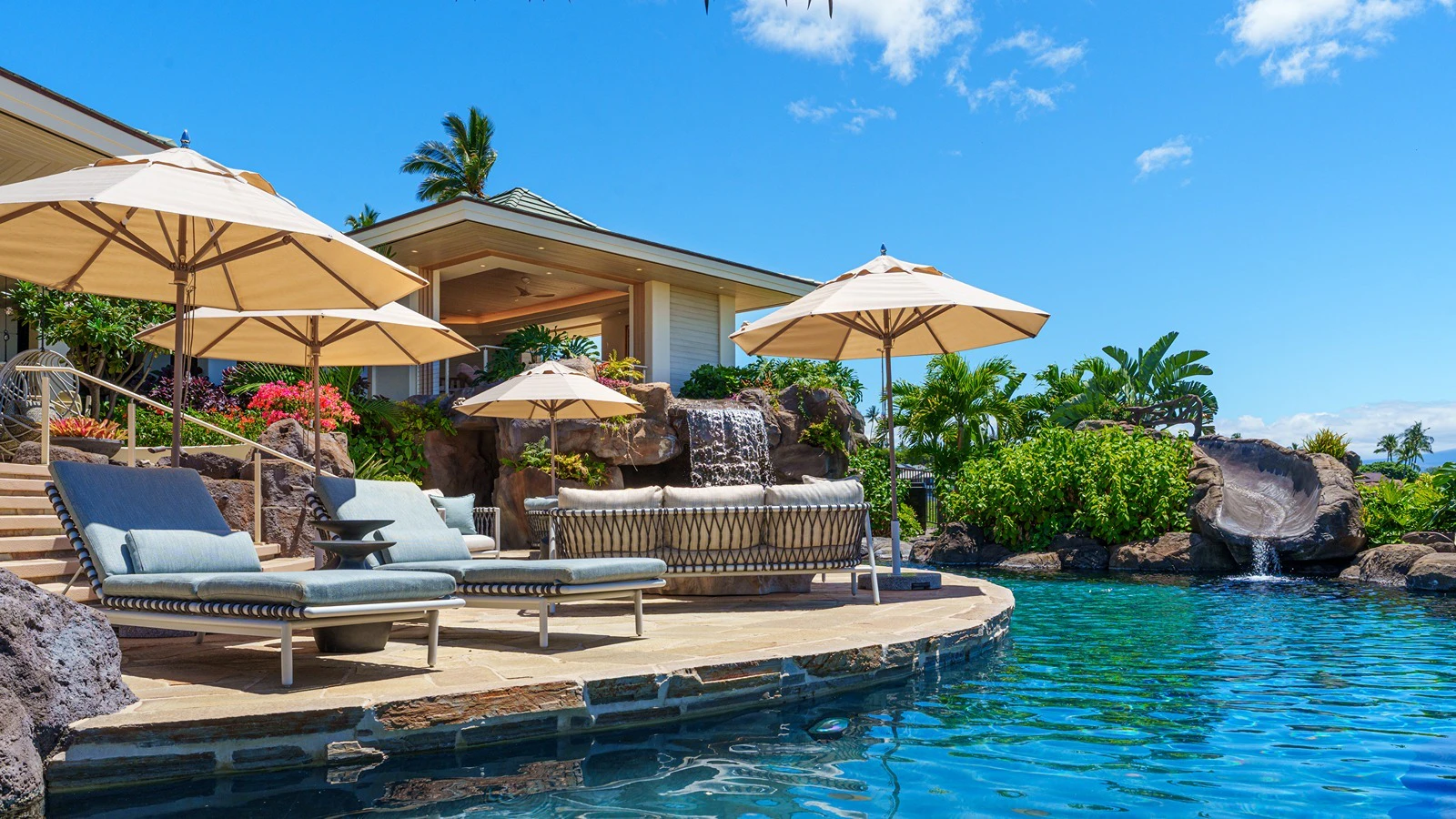 The home features a resort-style saltwater pool with waterslide, swim-up palapa bar and a waterfall grotto spa with integrated jacuzzi.