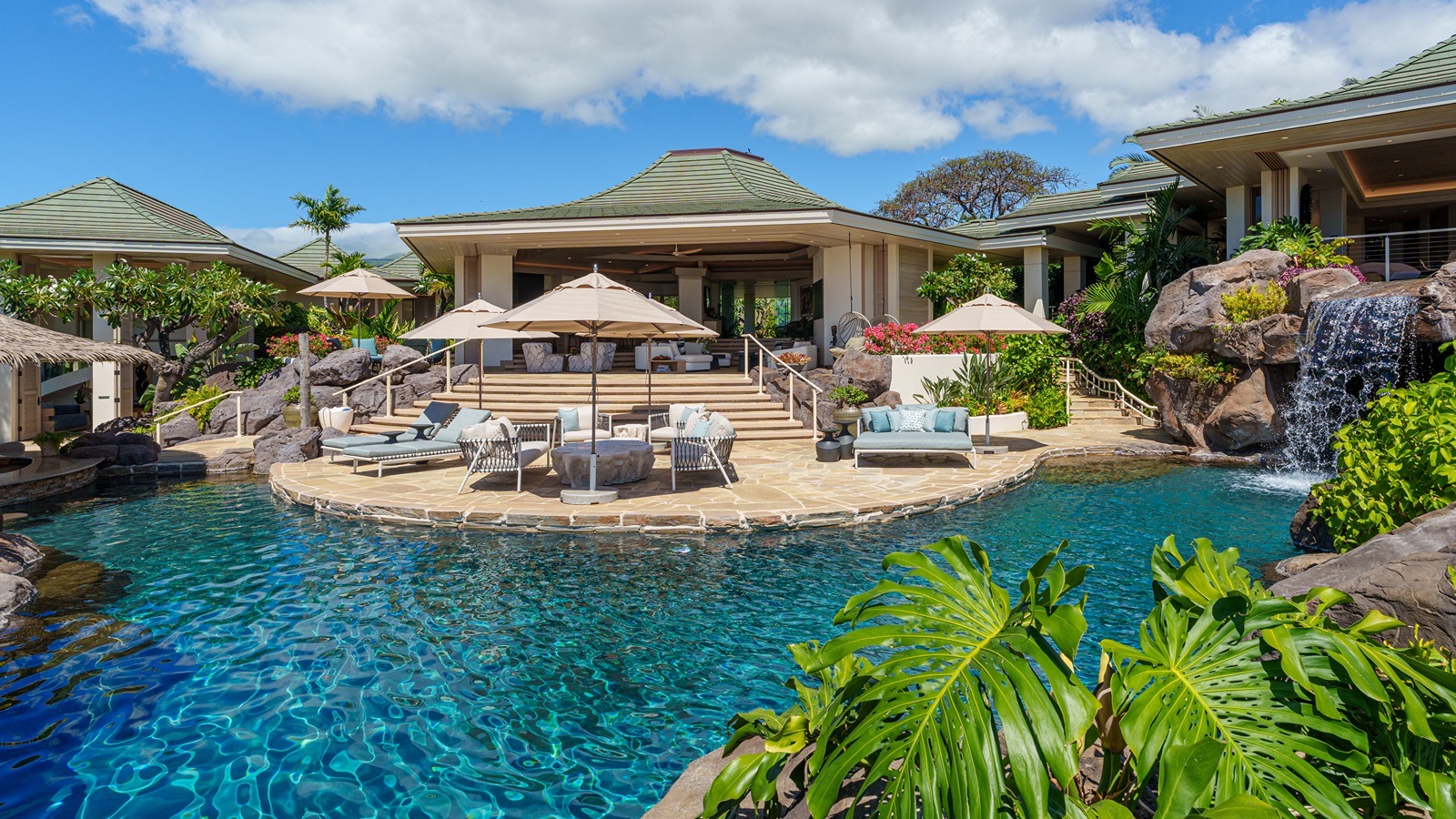 The home features a resort-style saltwater pool with waterslide, swim-up palapa bar and a waterfall grotto spa with integrated jacuzzi.