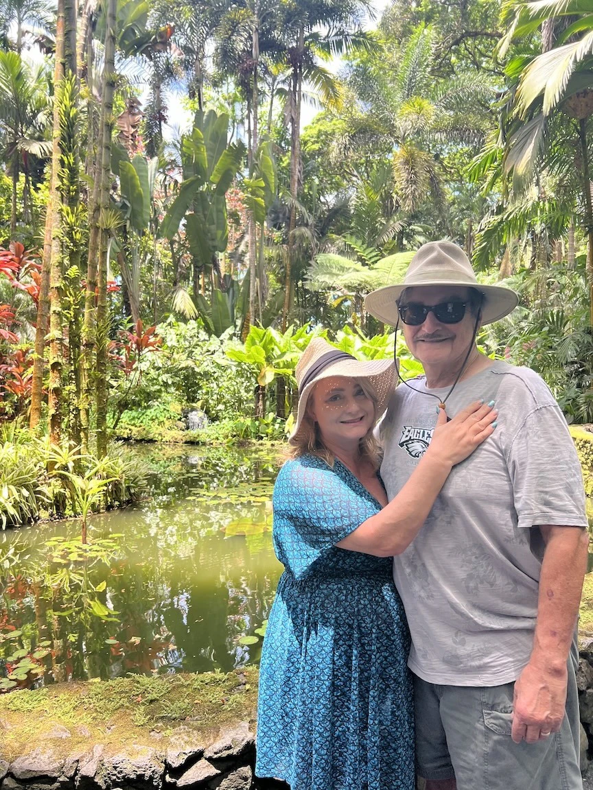 Wife and husband pictured in a botanical garden.