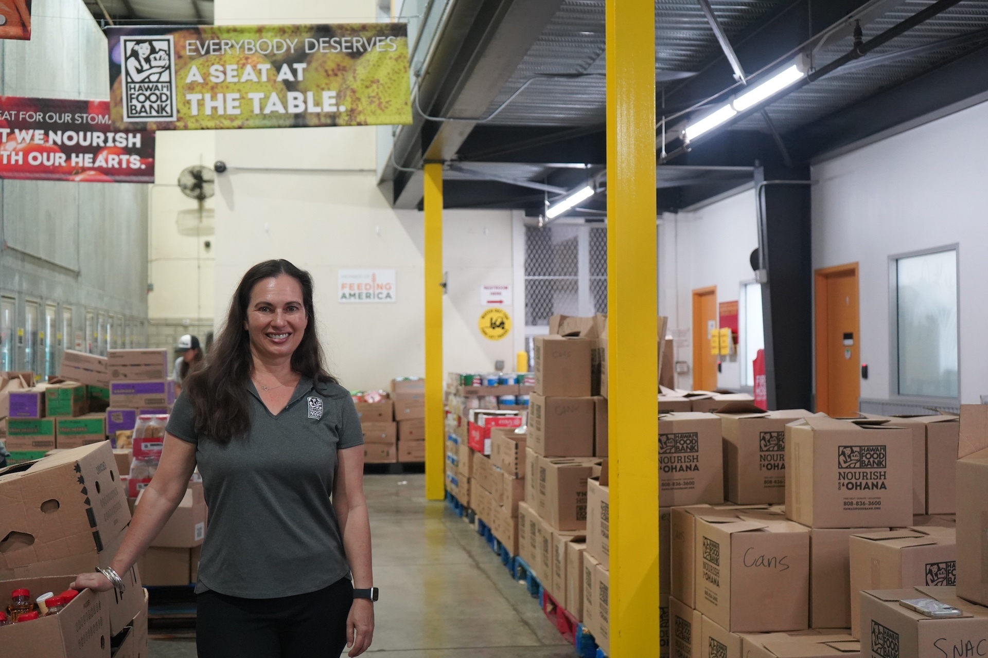 Prior to assuming the helm of Hawaiʻi Foodbank in May 2021, Amy Miller served in various roles at the Bishop Museum, the Academy of Natural Sciences in Philadelphia, and the The Dolphin Institute & Kewalo Basin Marine Mammal Lab. Here she is pictured at the foodbank's warehouse in Mapunapuna, Oʻahu. Photo by Kelsey Kukaua Medeiros.