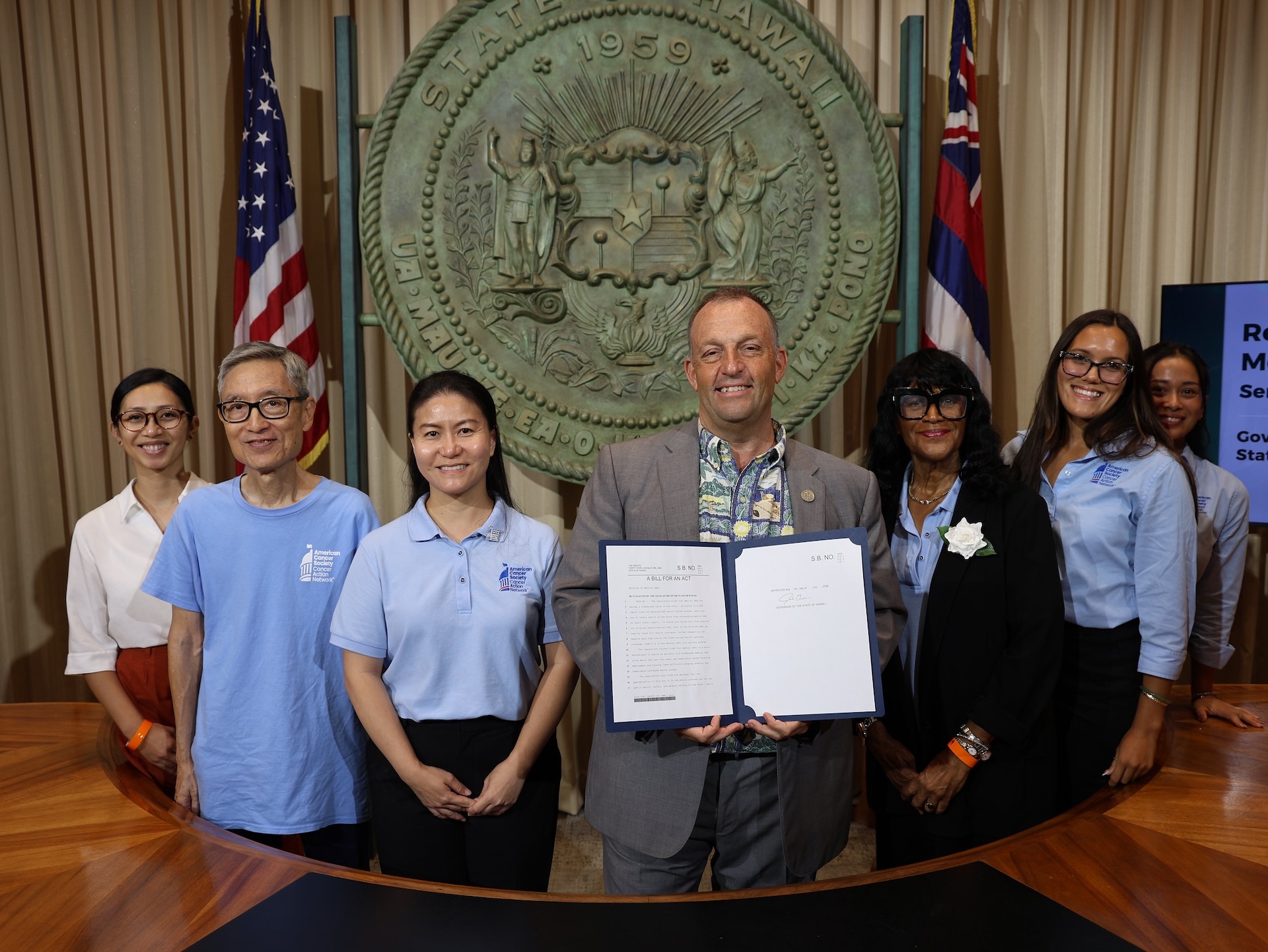 Gov. Josh Green pictured holding a signed HB 1969, which effective July 1, allocates state funding to increase access to colorectal cancer screenings and treatments statewide, along with members of the American Cancer Society Cancer Action Network Hawaiʻi team on Thursday, July 9, 2026.