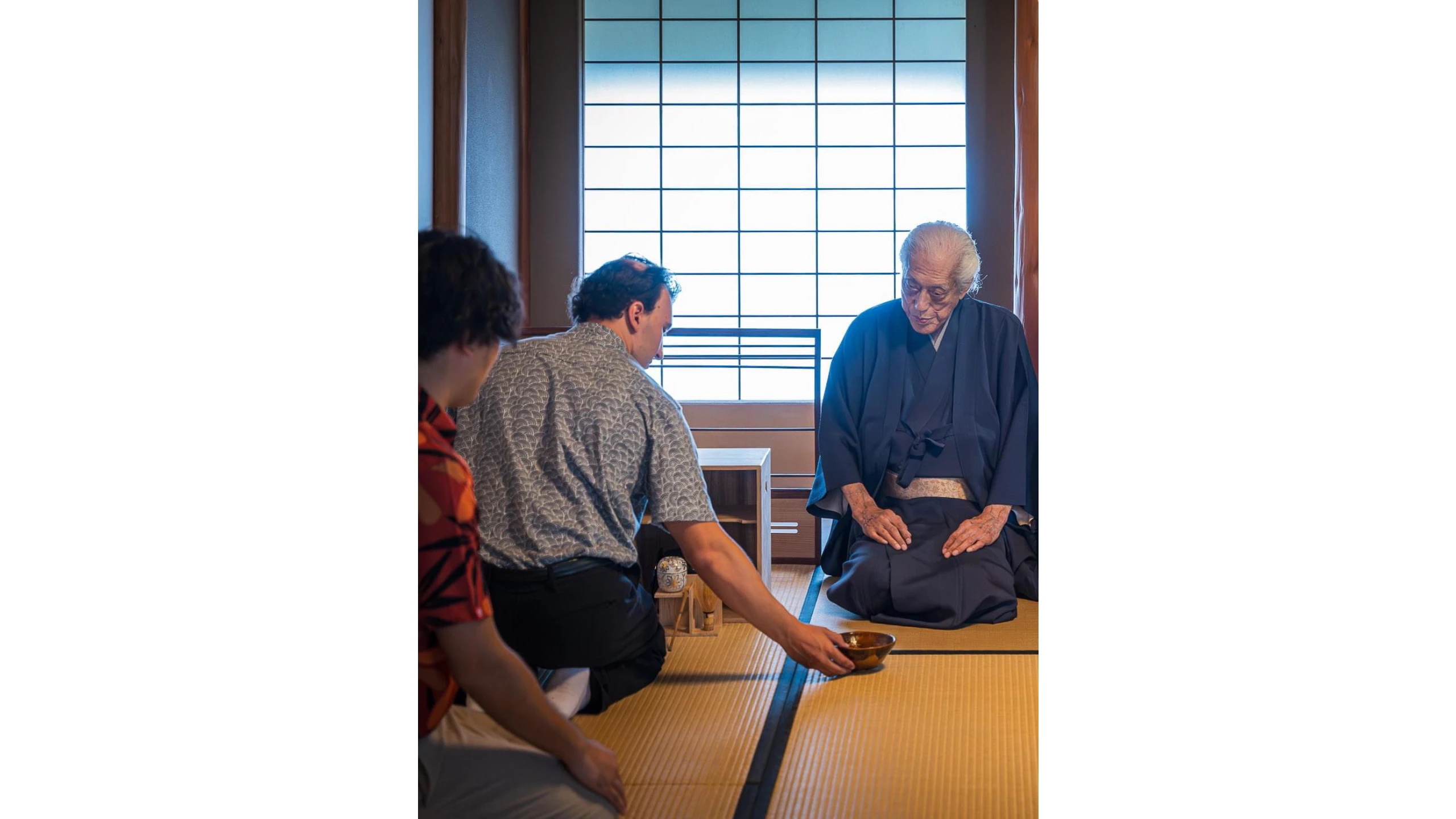 Justin serving Dr. Sen a bowl of tea.