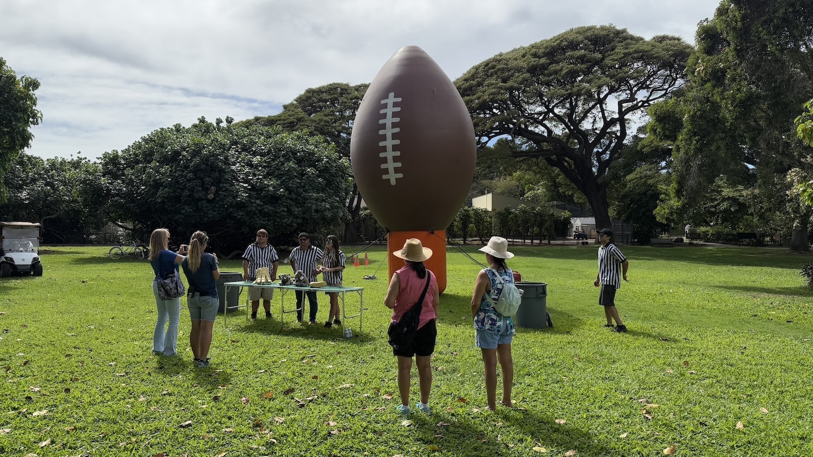 People gather around a large inflatable football at the zoo.