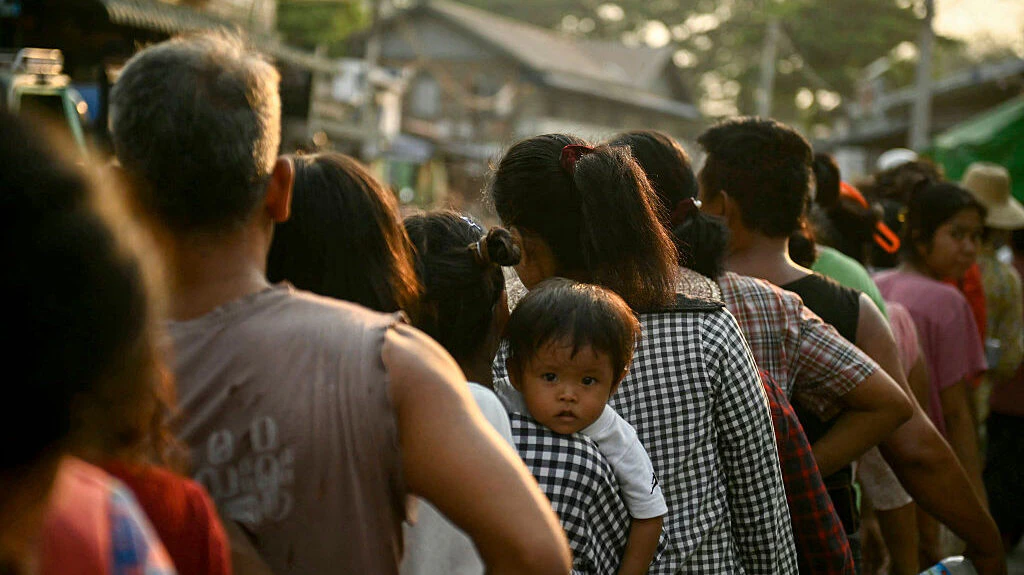 People line up for food aid distributed in Sagaing on April 2, 2025, five days after a major earthquake struck central Myanmar