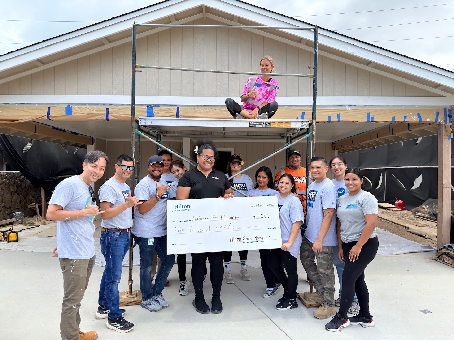 Employees of Hilton Grand Vacations present a check to Honolulu Habitat, which aims to provide affordable housing to local families. Pictured during a recent home build volunteer day in Waimānalo are Mitch Yokoyama, left, general manager of Hokulani Waikīkī, a Hilton Grand Vacations Club; and Feta Petelo, center, volunteer coordinator at Honolulu Habitat.
