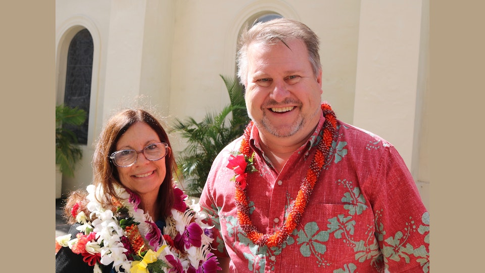 Two nonprofit leaders smile for a photo in front of Cathedral Basilica of Our Lady of Peace in Downtown Honolulu.