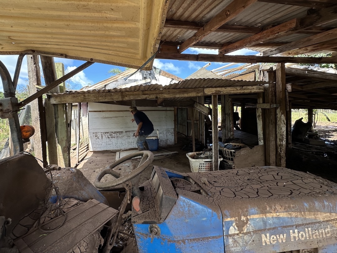 Thy Cavan, a farmer at Otake Camp, points to where the water reached at his house.