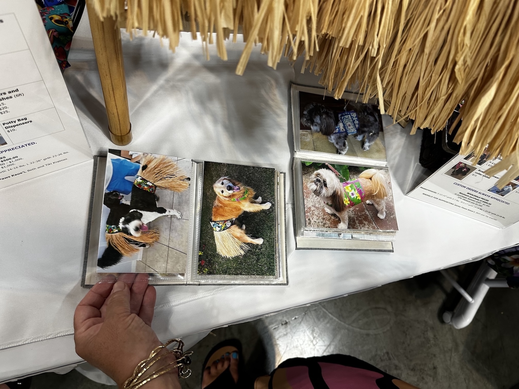 The Aloha Paws Kaua’i booth has a photo album featuring pictures of pets wearing its fashion.