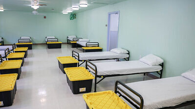 Beds and storage bins in a room.