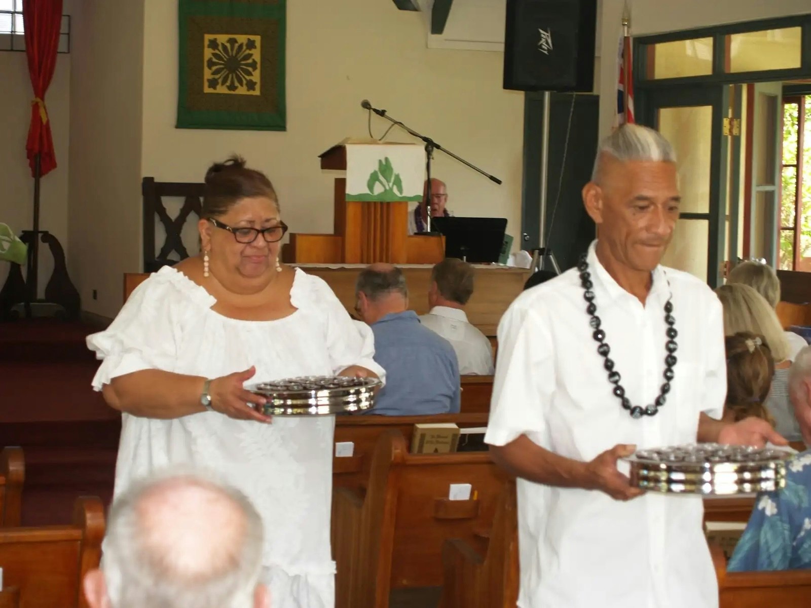 Two people present communion at church.