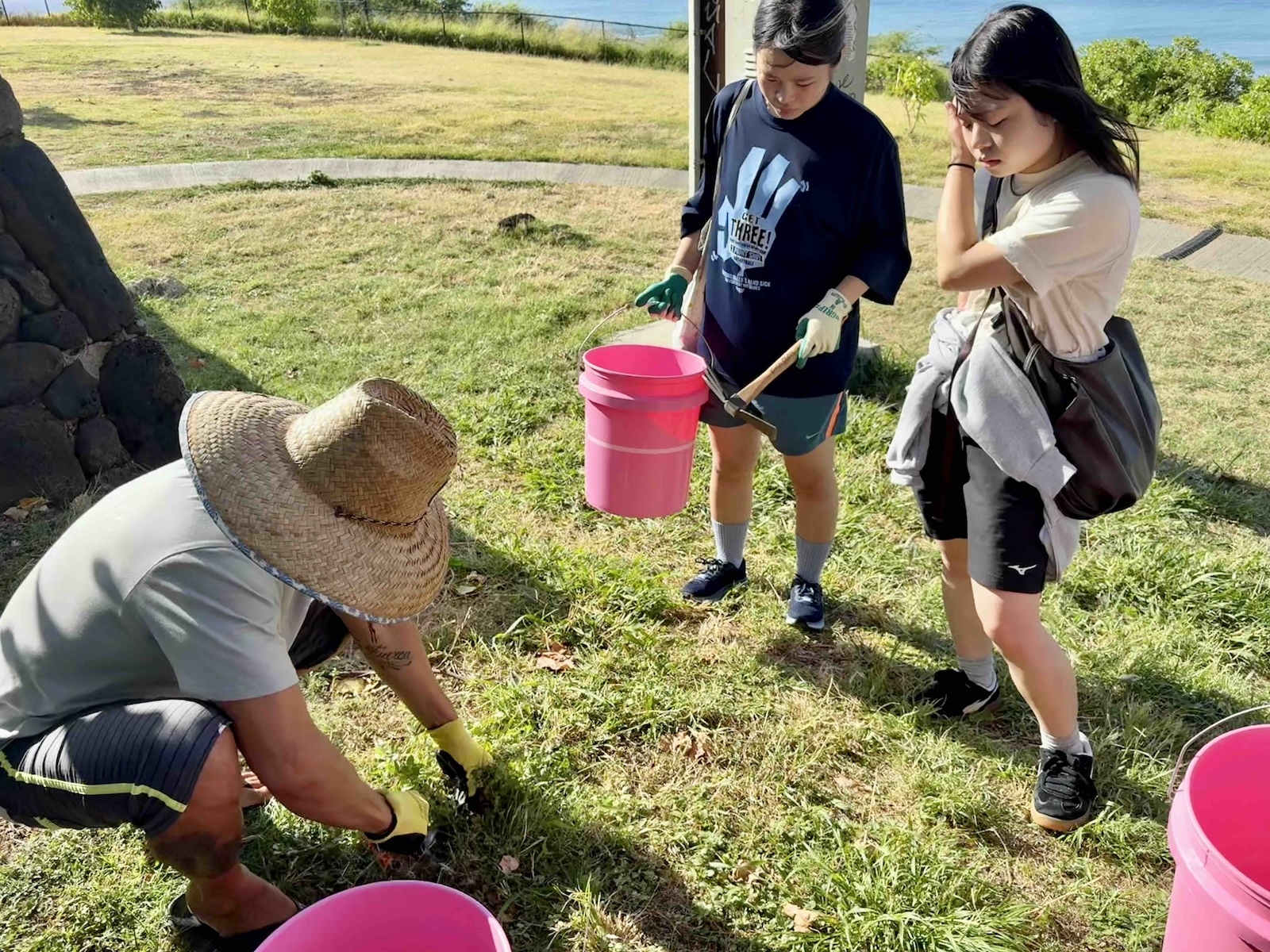 Esteban demonstrates how to remove Khaki weed, or "pokies,” while replanting native species into the dirt at Kuilei Cliffs Beach Park, for which the nonprofit is named. Photo by Kelsey Kukaua Medeiros