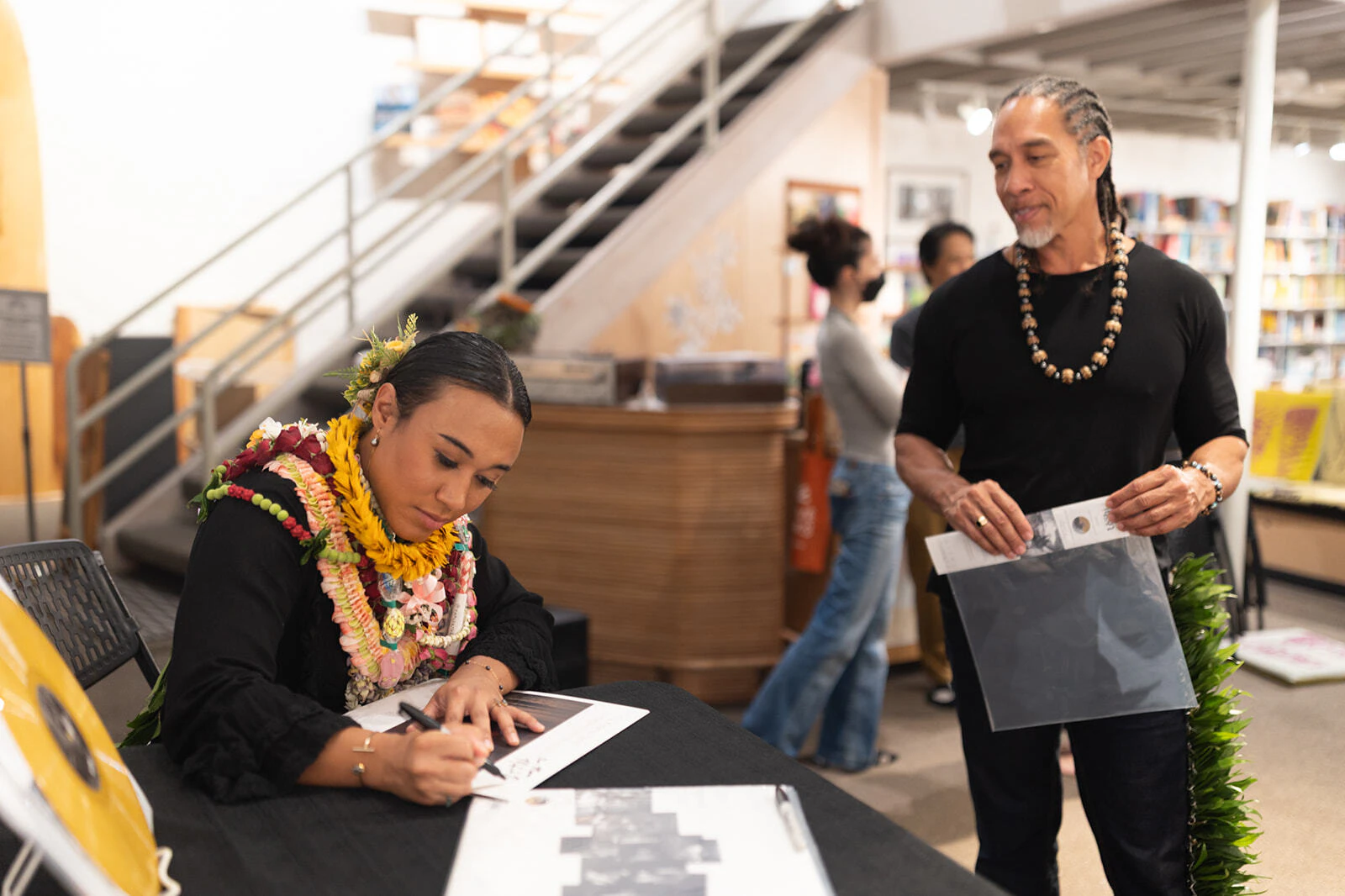 T.J. Keanu Tario, left, signs a record for Moses Goods.