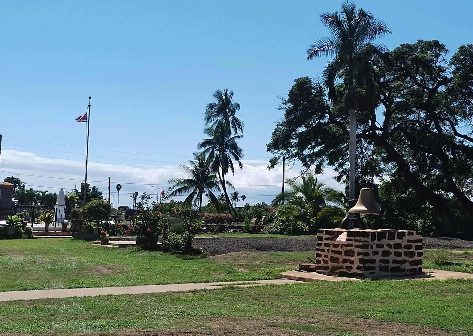 A recent photo of the historic site of Waiola Church, after the 2023 Lahaina fire. This view includes an empty lot, the bell and cemetery.