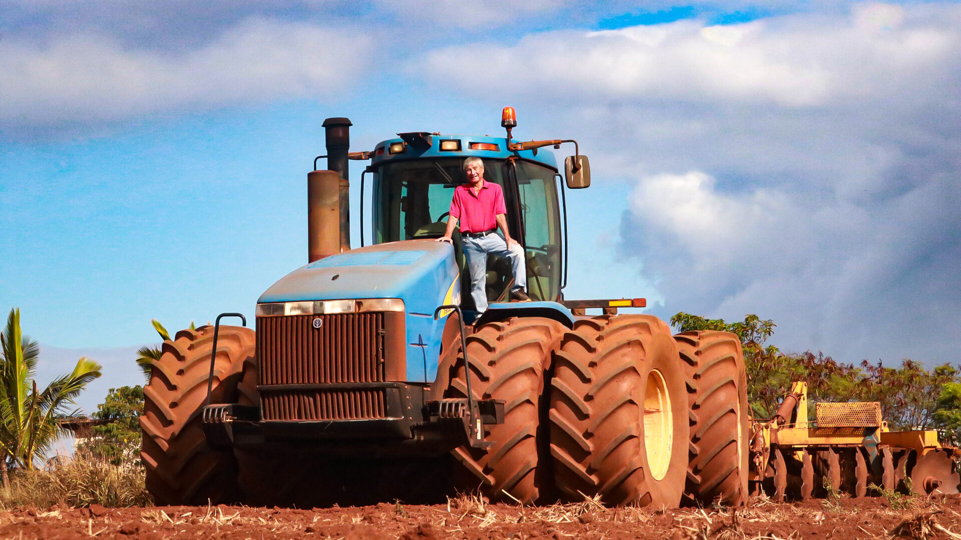 Melvin Matsuda stands on a New Holland TJ500 tractor, the biggest tractor he and Clyde Fukuyama could buy when they launched land preparation services in 2004. The mammoth tractor was 12.5 feet tall and 26.5 feet long.