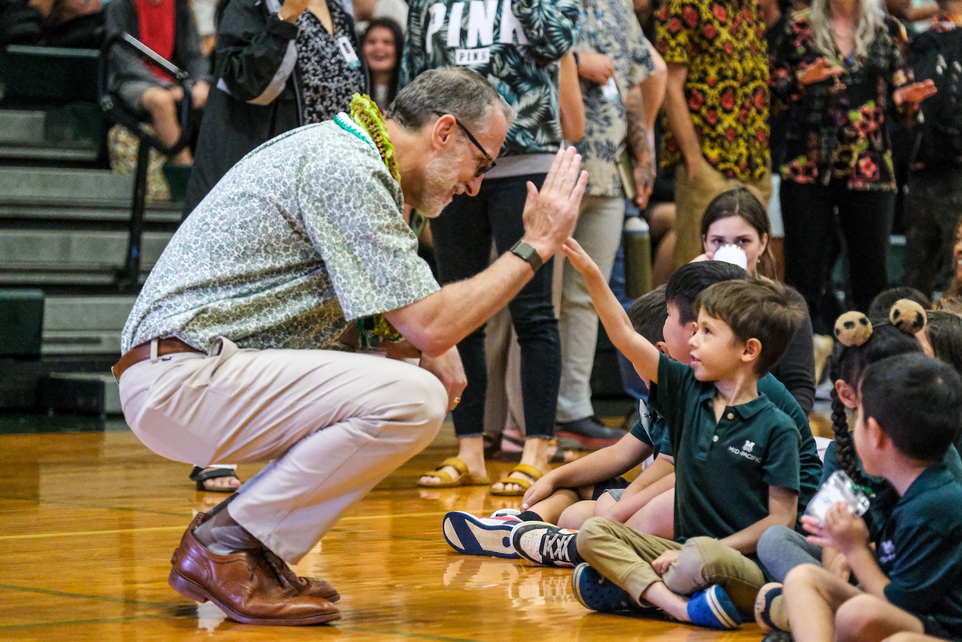 Mid-Pacific Institute President Paul Turnbull high-fives one of the school’s youngest Owls at Opening Convocation.