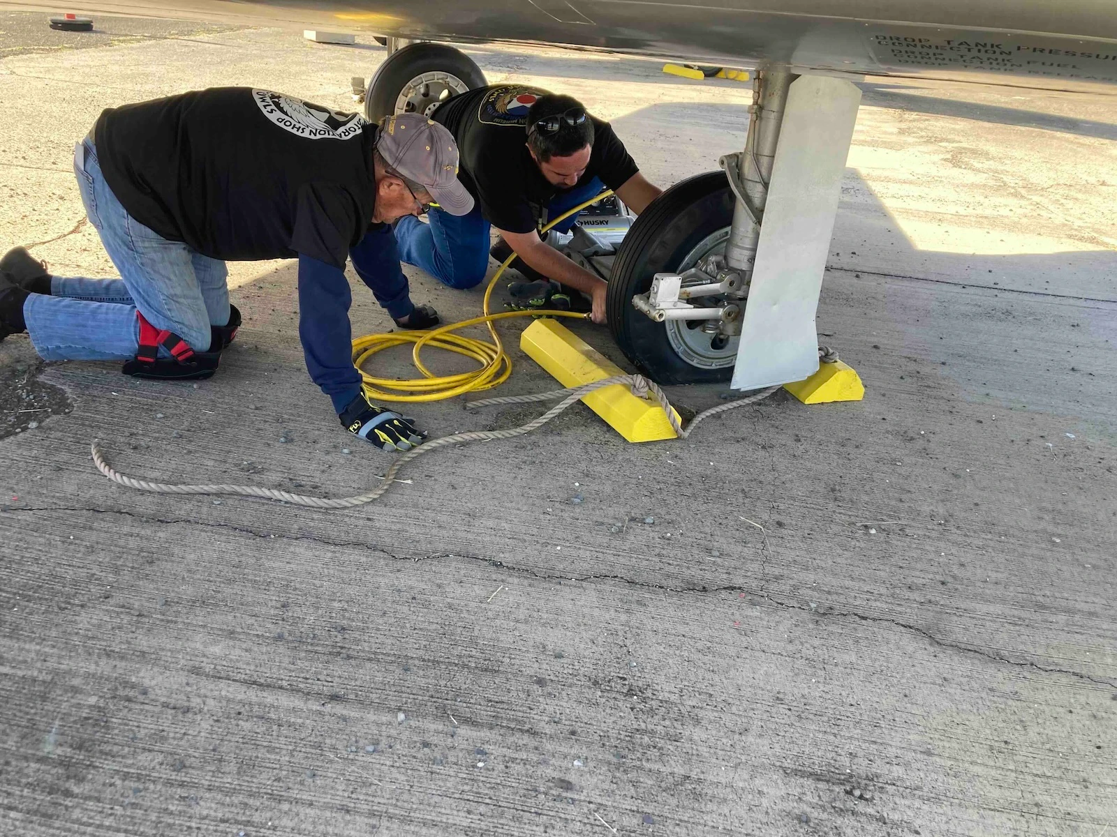 Montgomery (wearing gray cap) and Mike Tobin, PHAM’s restoration shop manager and exhibits fabricator, fill air in a tire of an F-86E Sabre jet, America's primary fighter plane during the Korean War. Credit: PHAM.