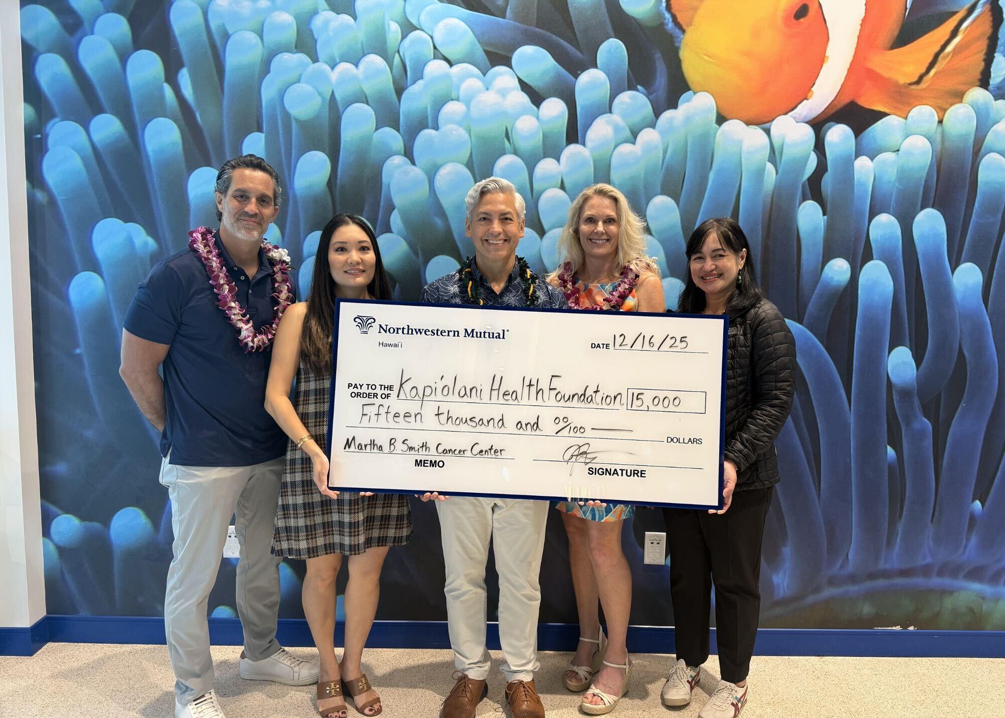 Jamie Delgadillo, center, managing partner of Northwestern Mutual Hawaiʻi, presents a $15,000 check to Kapiʻolani Health Foundation in 2025.