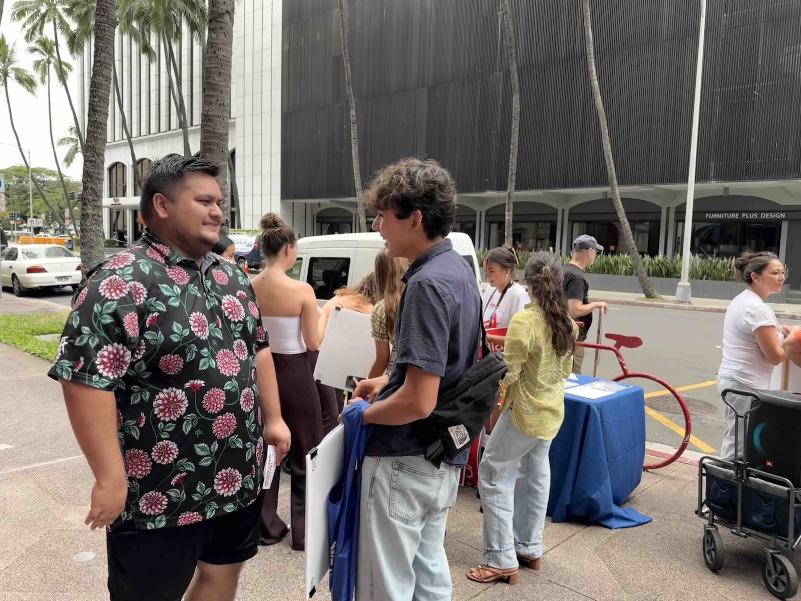 Punahou School student Zane Dalgamouni, right, served as the main organizer of the protest with Indivisible Hawai’i. He is pictured talking with a Punahou alum on Monday. Photo by Kelsey Kukaua Medeiros
