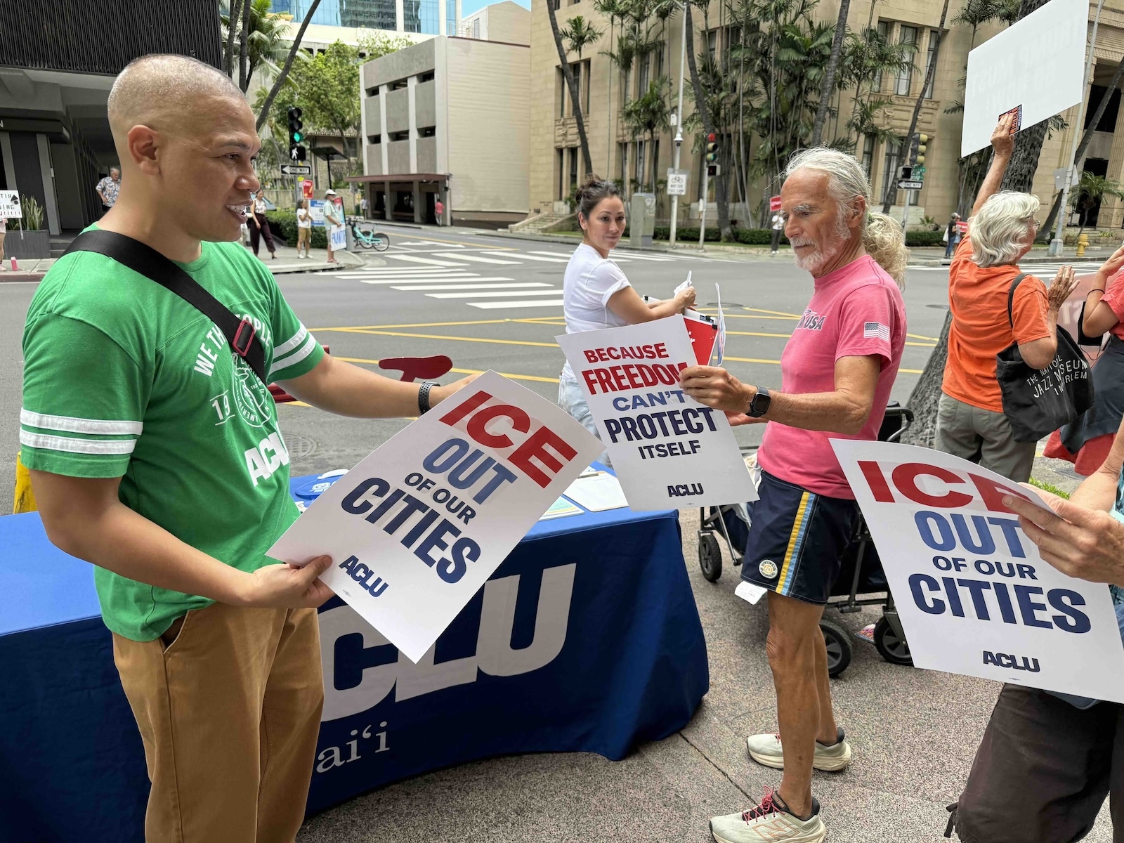 Sergio Alcubilla, community engagement director for American Civil Liberties Union (ACLU) of Hawaiʻi, passes out signs. Photo by Kelsey Kukaua Medeiros