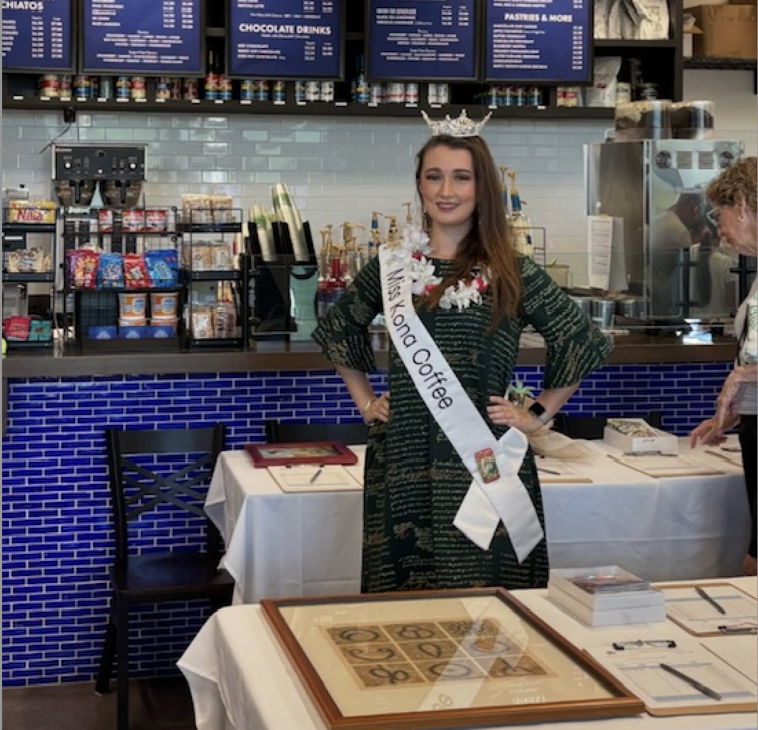 Miss Kona Coffee in Kohala Coffee pictured by a silent auction table from a previous Walk.