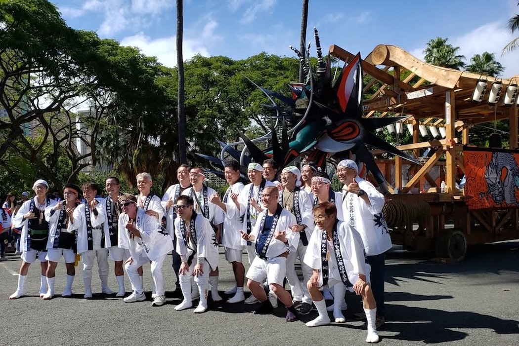 Group pictured in front of large dragon float in Japan.