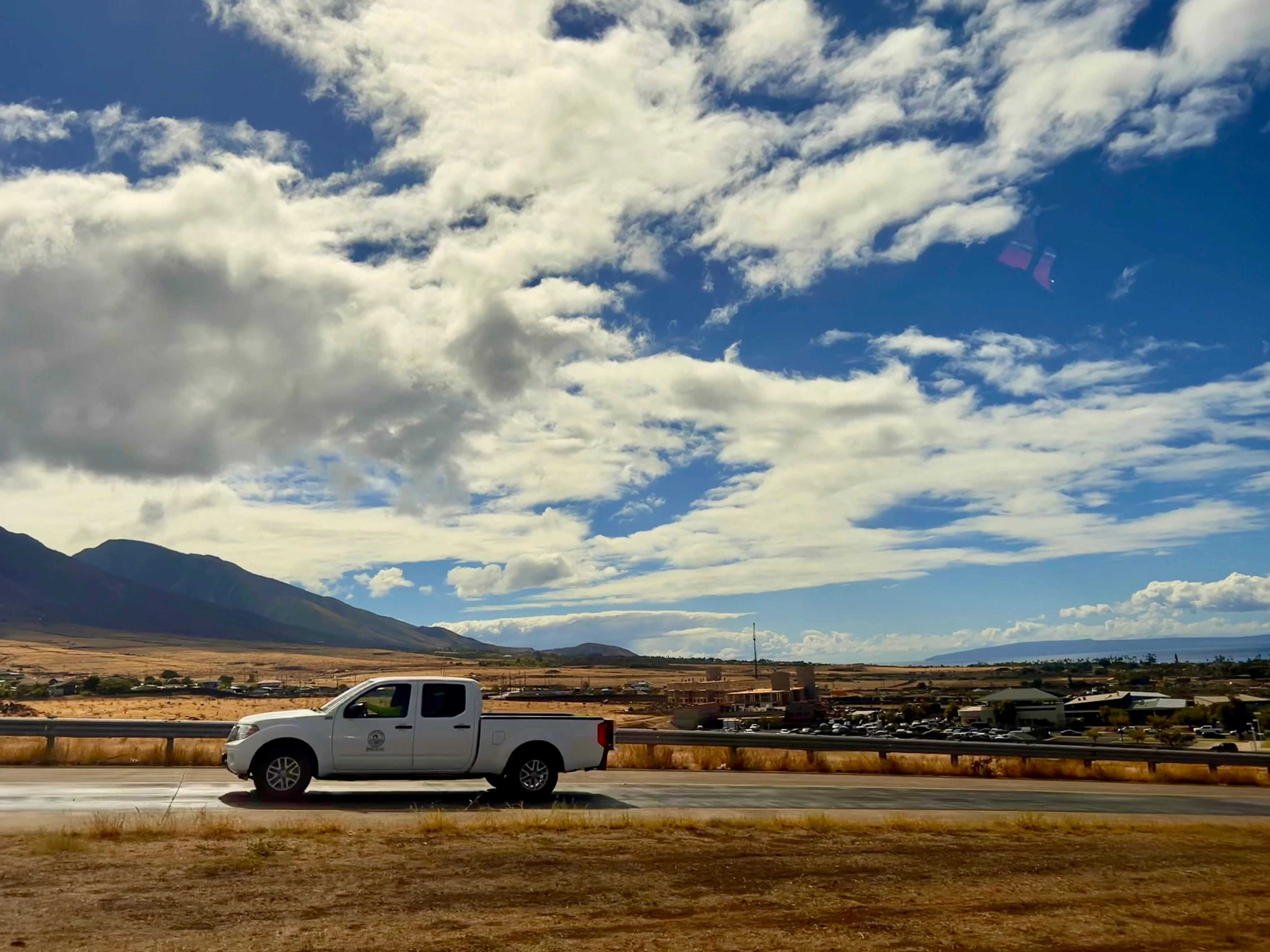File photo of County of Maui vehicle driving through West Maui, following the 2023 Lahaina fire. PC: Kelsey Medeiros, October 2024
