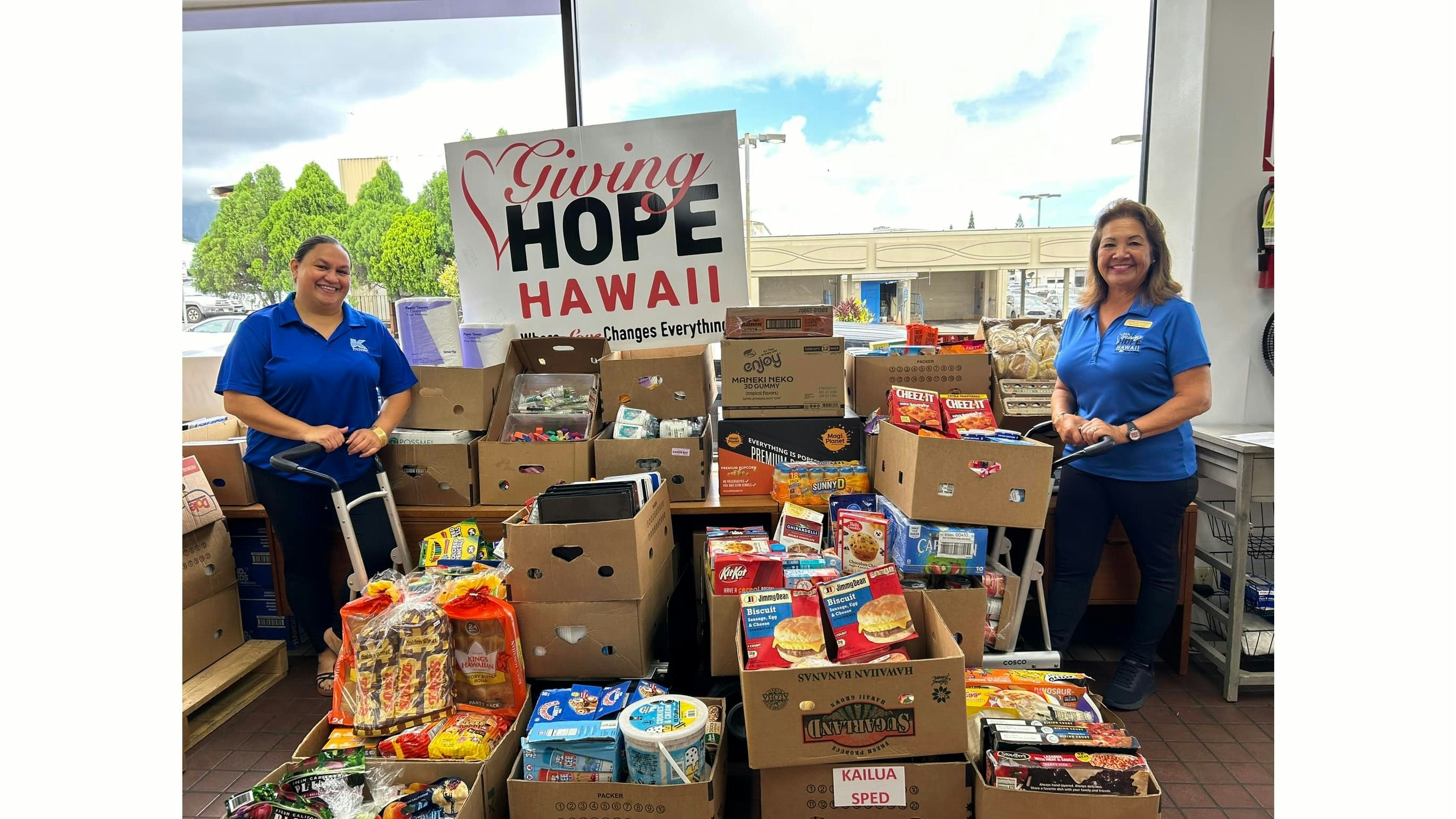 Two volunteers pictured with food donations.