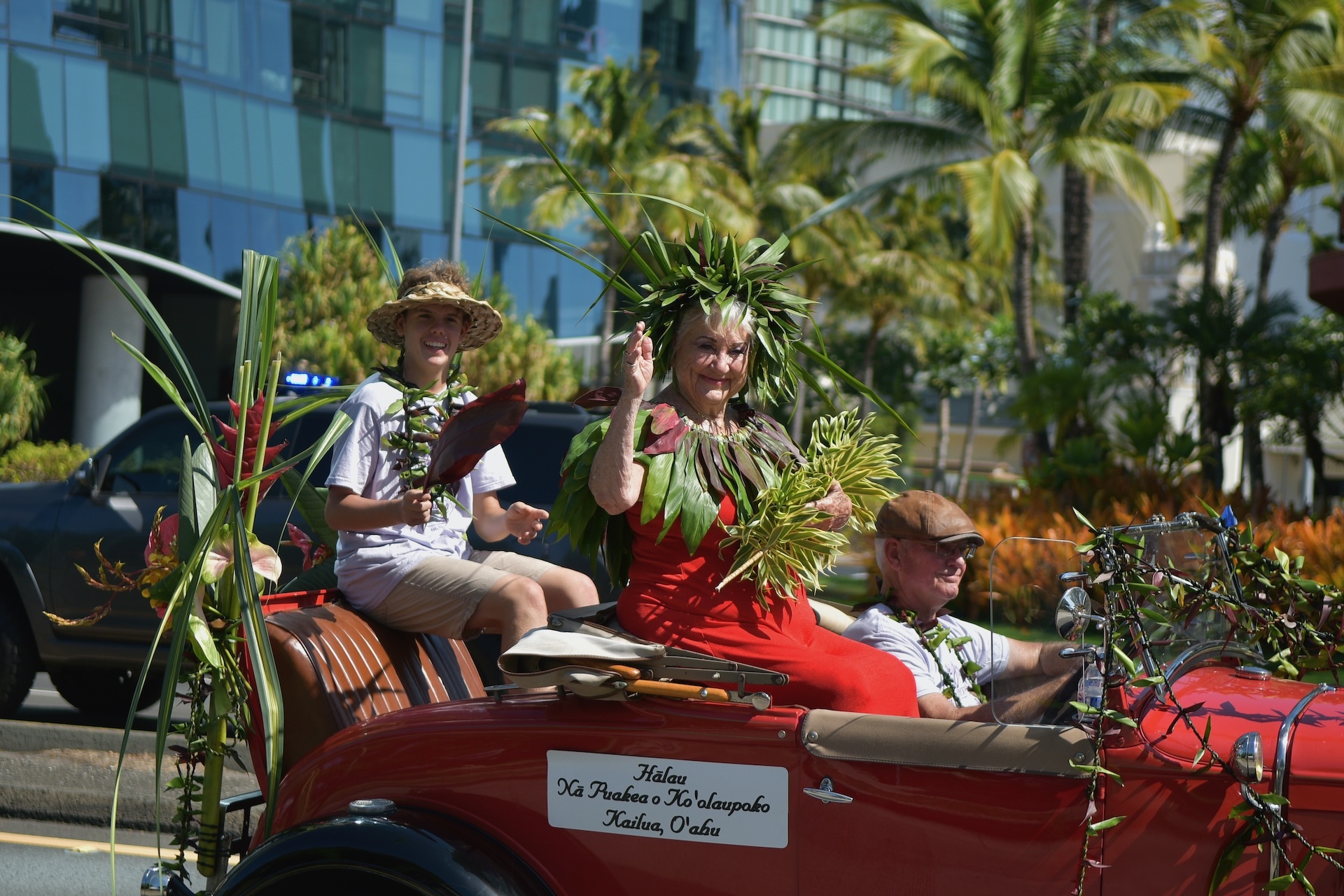Kumu Hula Pattye Wright waves to spectators in the 2023 Aloha Festivals Floral Parade.
