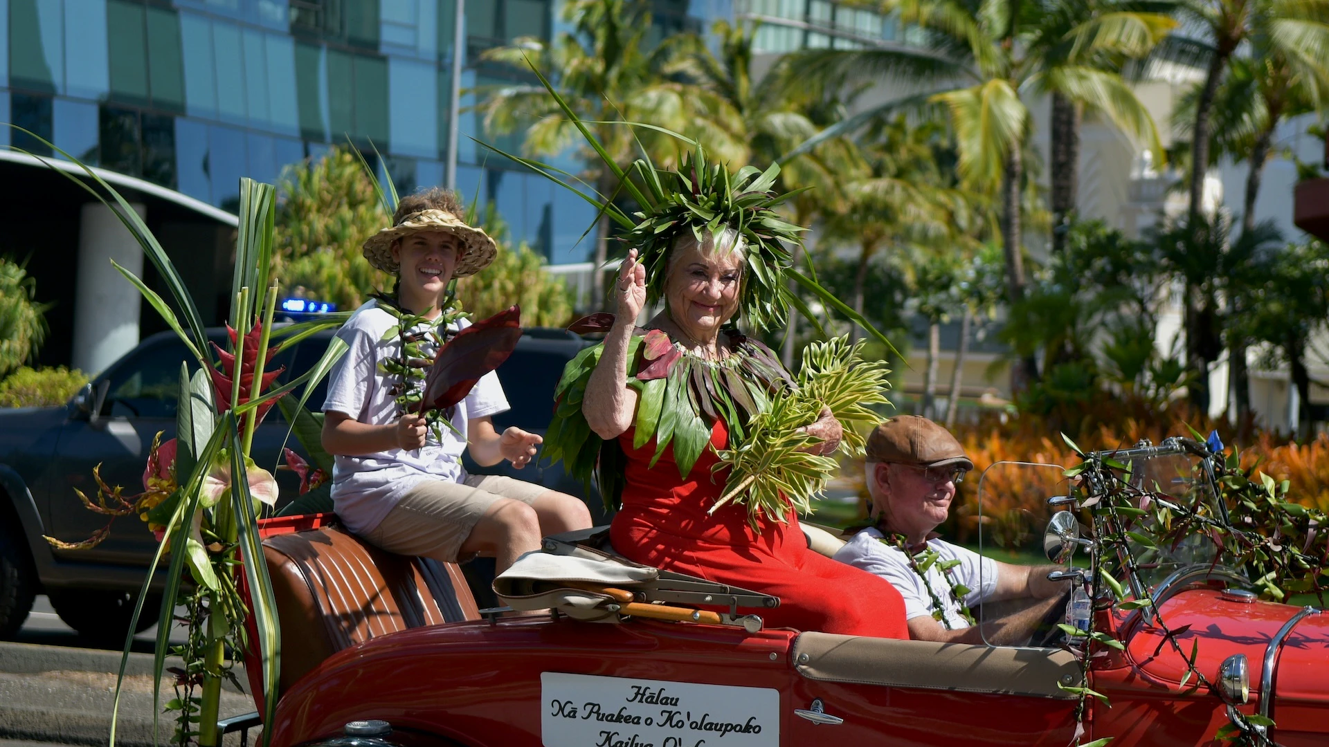 Kumu Hula Pattye Wright waves to spectators in the 2023 Aloha Festivals Floral Parade.