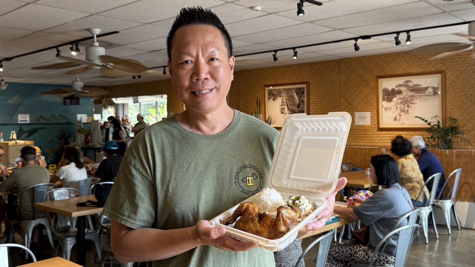 Thomas Yip holds a plate of the business’s signature huli huli chicken.
