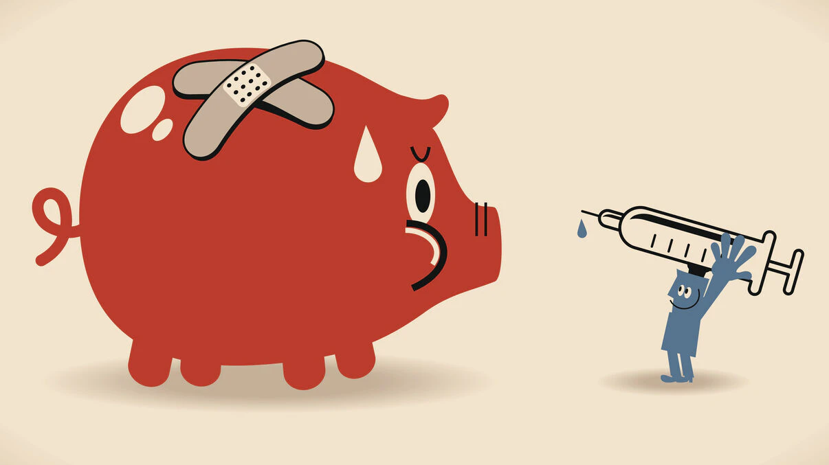 A man with a syringe takes aim at a piggy bank