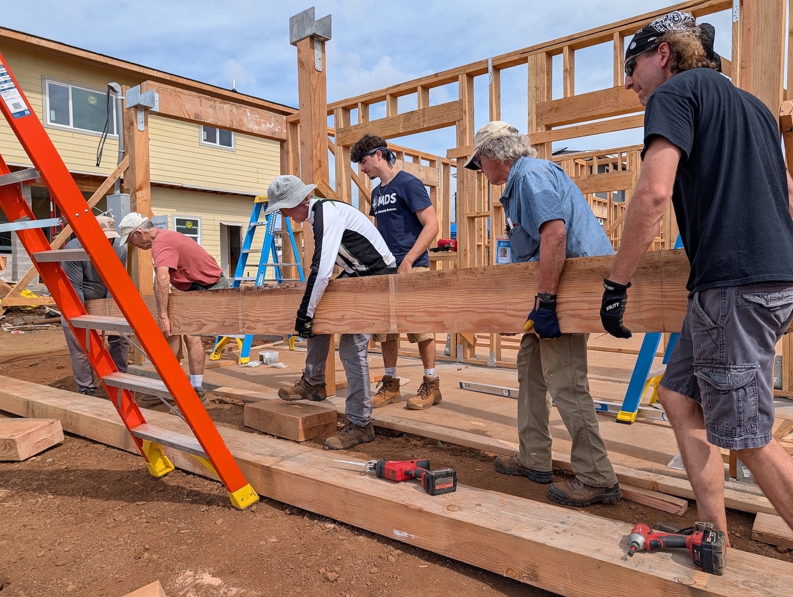 Volunteers install structural beams at a home rebuild site in Lahaina, supporting long-term recovery for families impacted by the August 2023 wildfires.