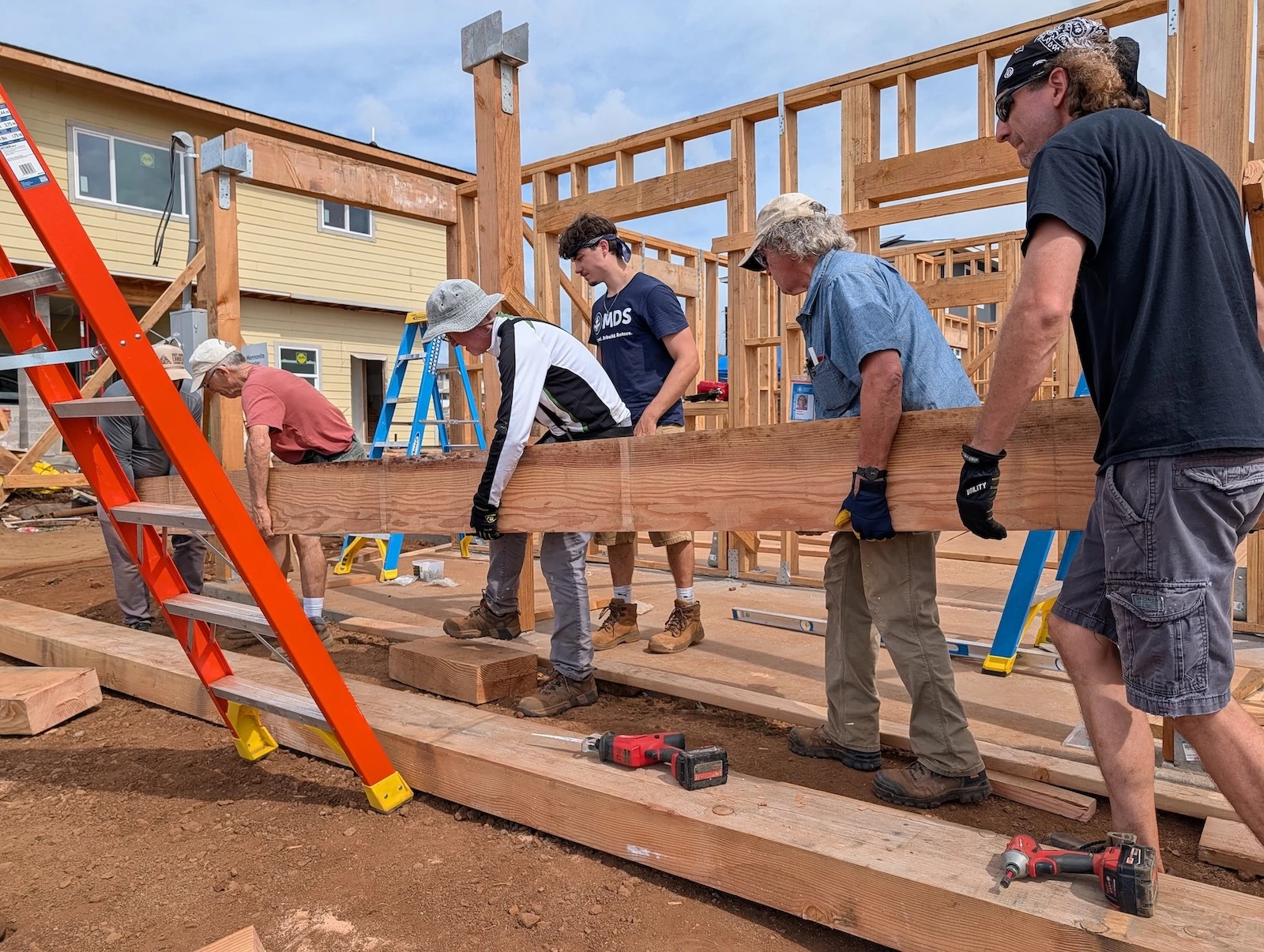 Volunteers install structural beams at a home rebuild site in Lahaina, supporting long-term recovery for families impacted by the August 2023 wildfires.