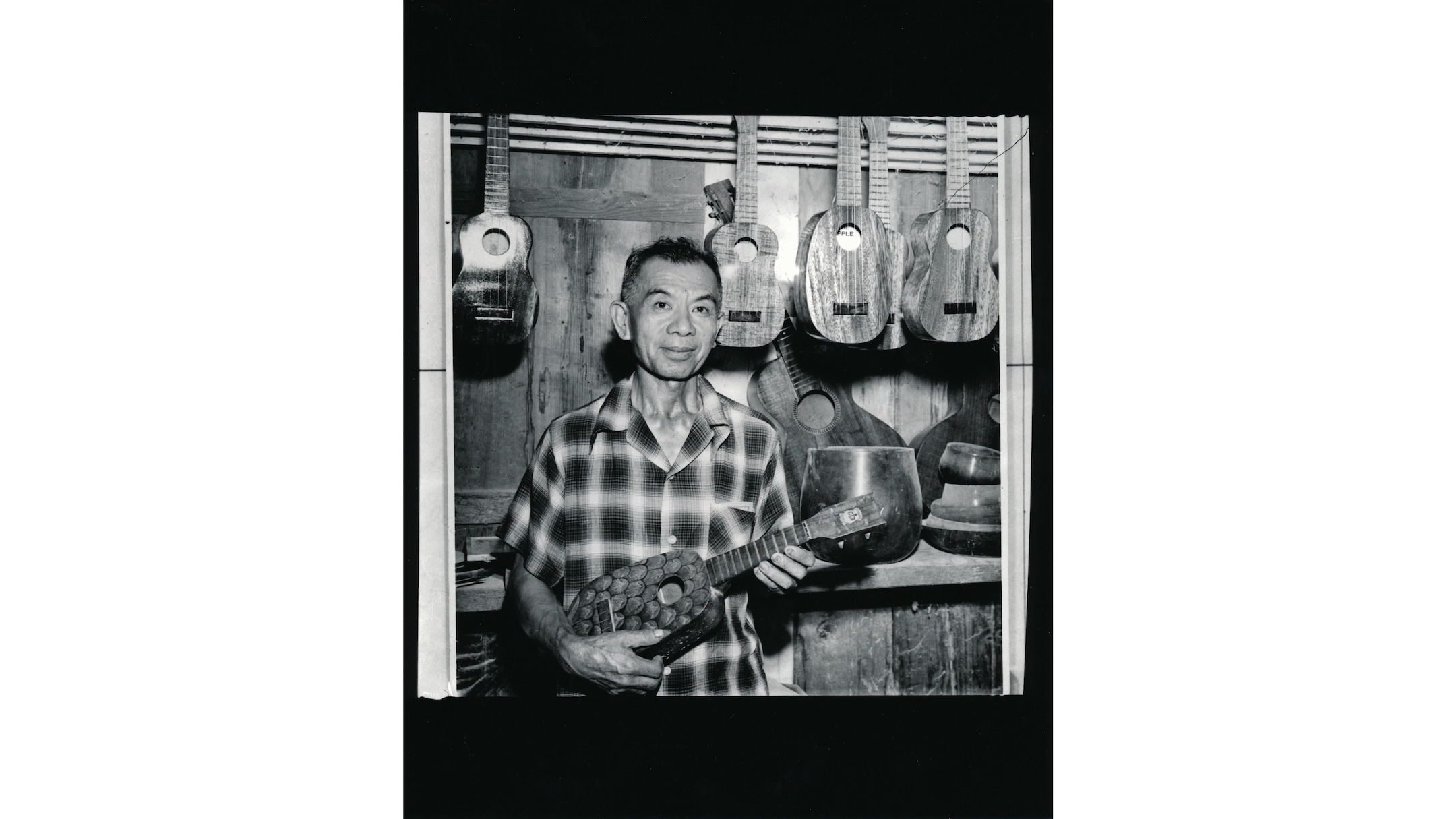 Sam Kamaka Sr. holds a pineapple ʻukulele in the early 1950s.
