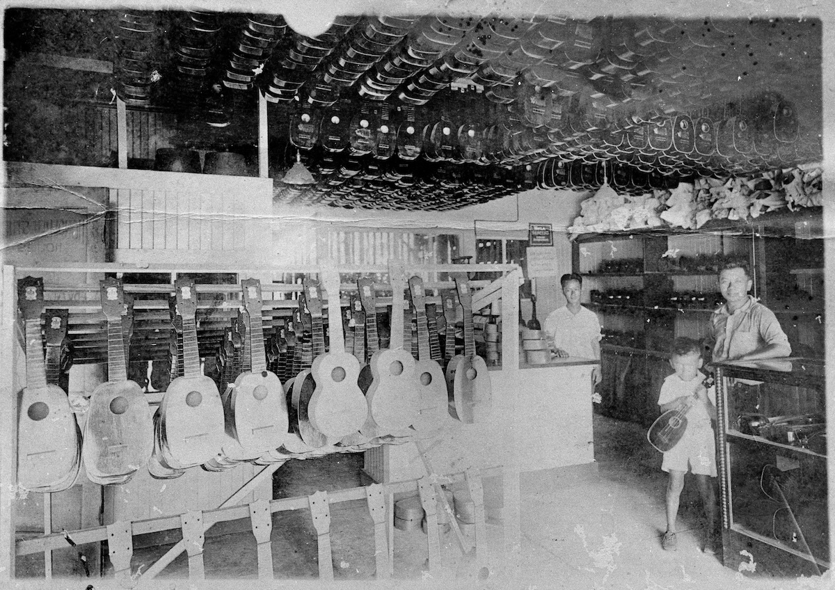 A historical photo of Kamaka ʻUkulele and Guitar Works that shows inside the store on South King Street.