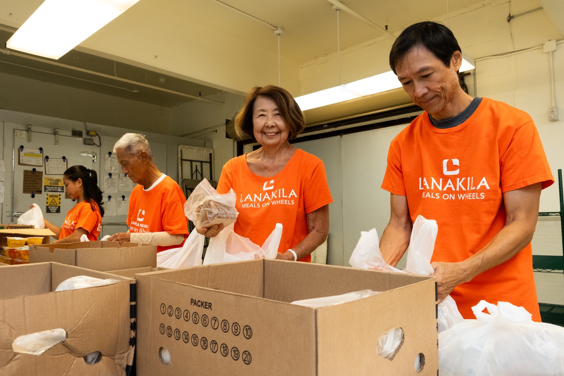 Volunteers are needed to continue carrying out Lanakila Pacific's mission on Oʻahu. Pictured here: Meals on Wheels volunteers pack food to go out directly to kūpuna.