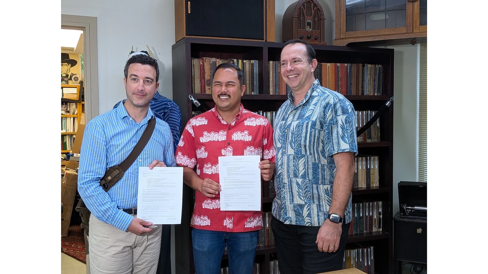 From left: Felipe Ramalheira, Consul General for Portugal in San Francisco, Honorary Consul for Portugal Tyler Dos Santos-Tam, and State Archivist Adam Jansen. Ramalheira and Santos-Tam are holding copies of the agreement gifting scanned records to the Hawai‘i State Archives.
