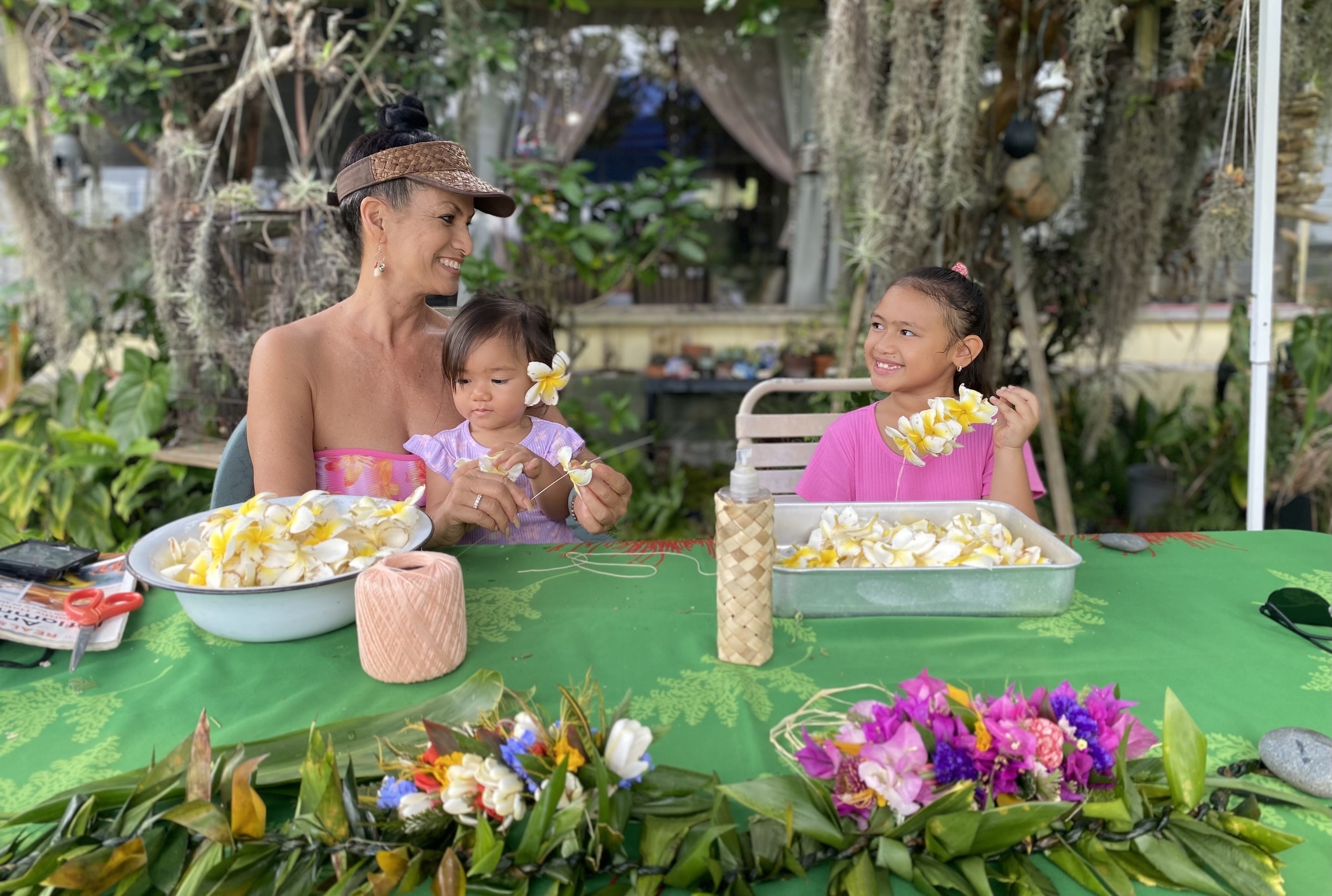 Plumerias are a favorite of this year’s Lei Queen Puamana Garcia, shown here teaching her granddaughters how to kui lei.