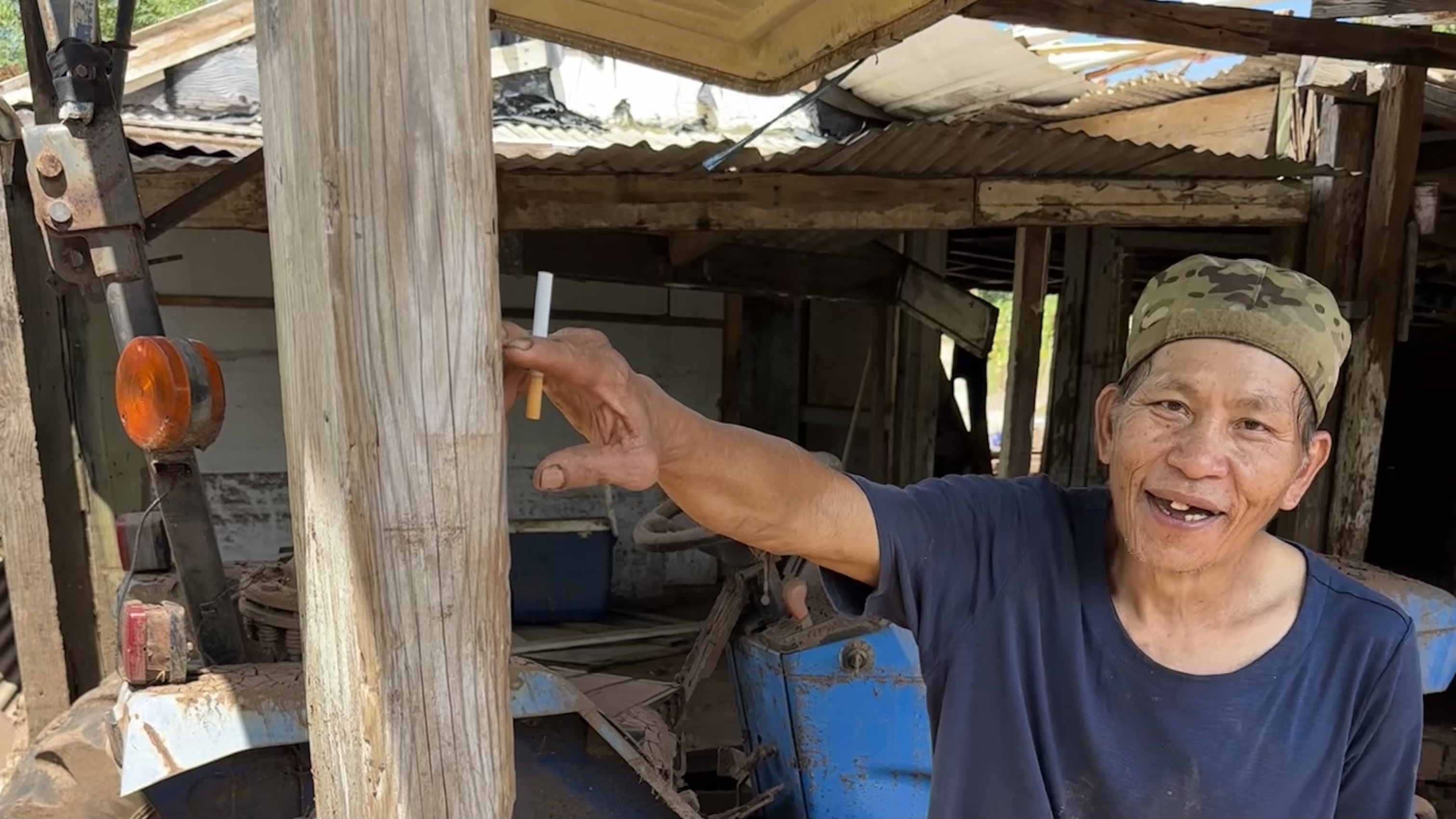 Farmer Thy Cavan points to how high the water came when it flooded his home and crops. It covered his tractor, which is a total loss.