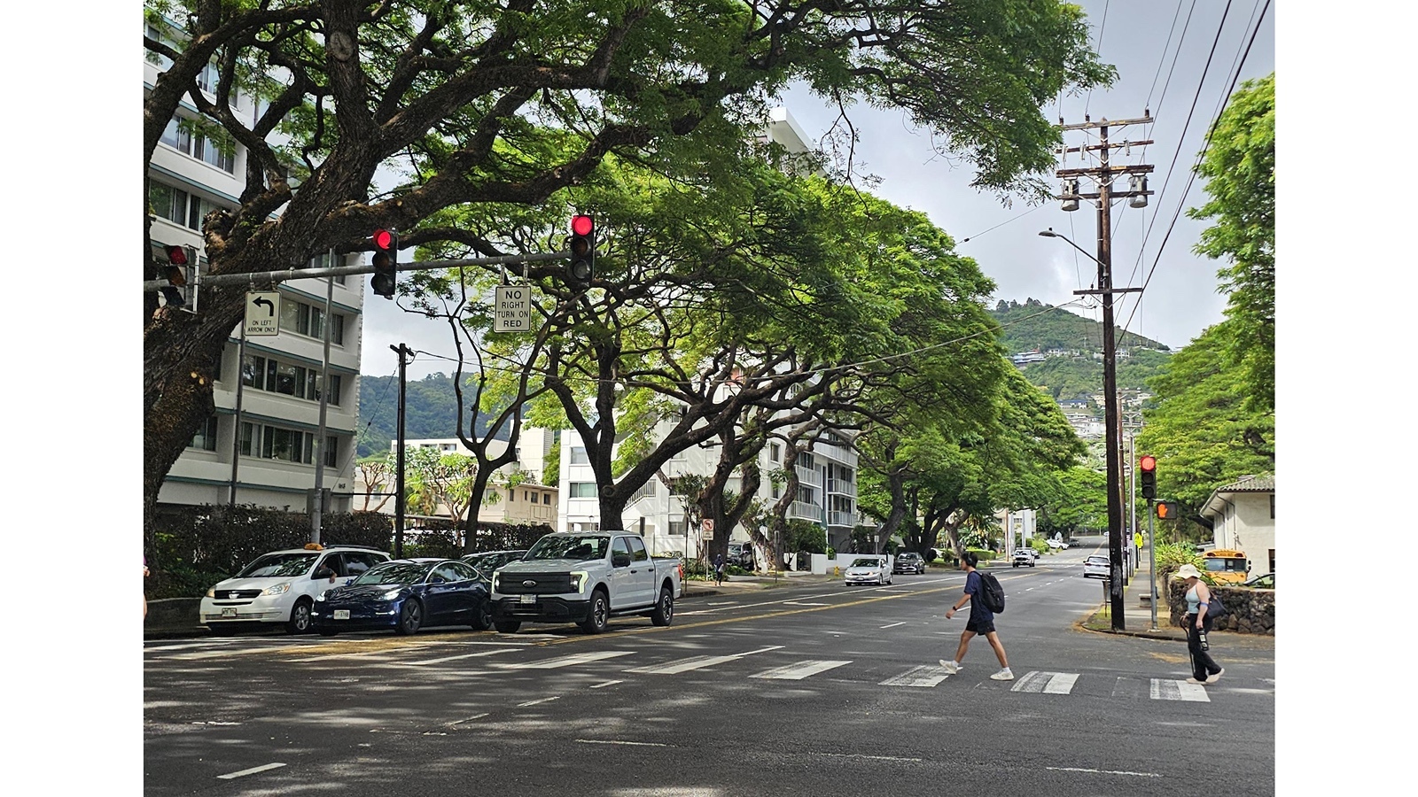 A man crosses the street in Makiki.