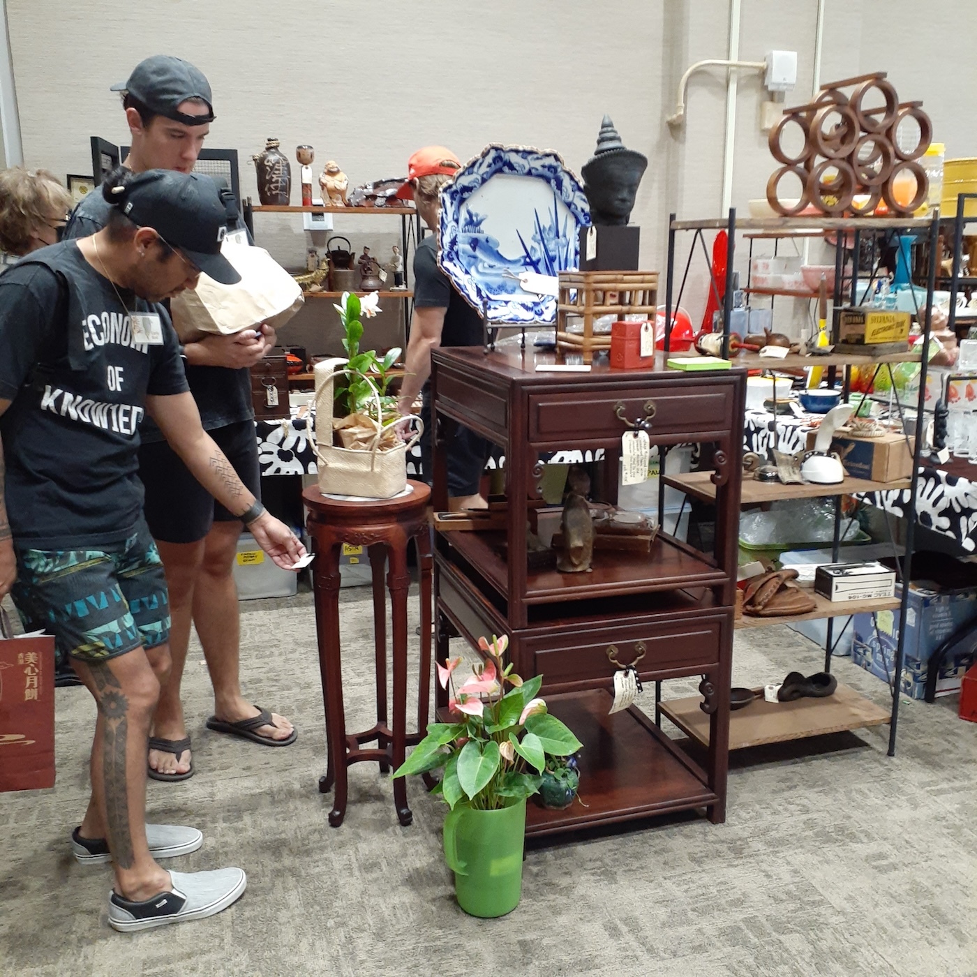 People shop Chinese tables, circa 1950s, made of solid rosewood.